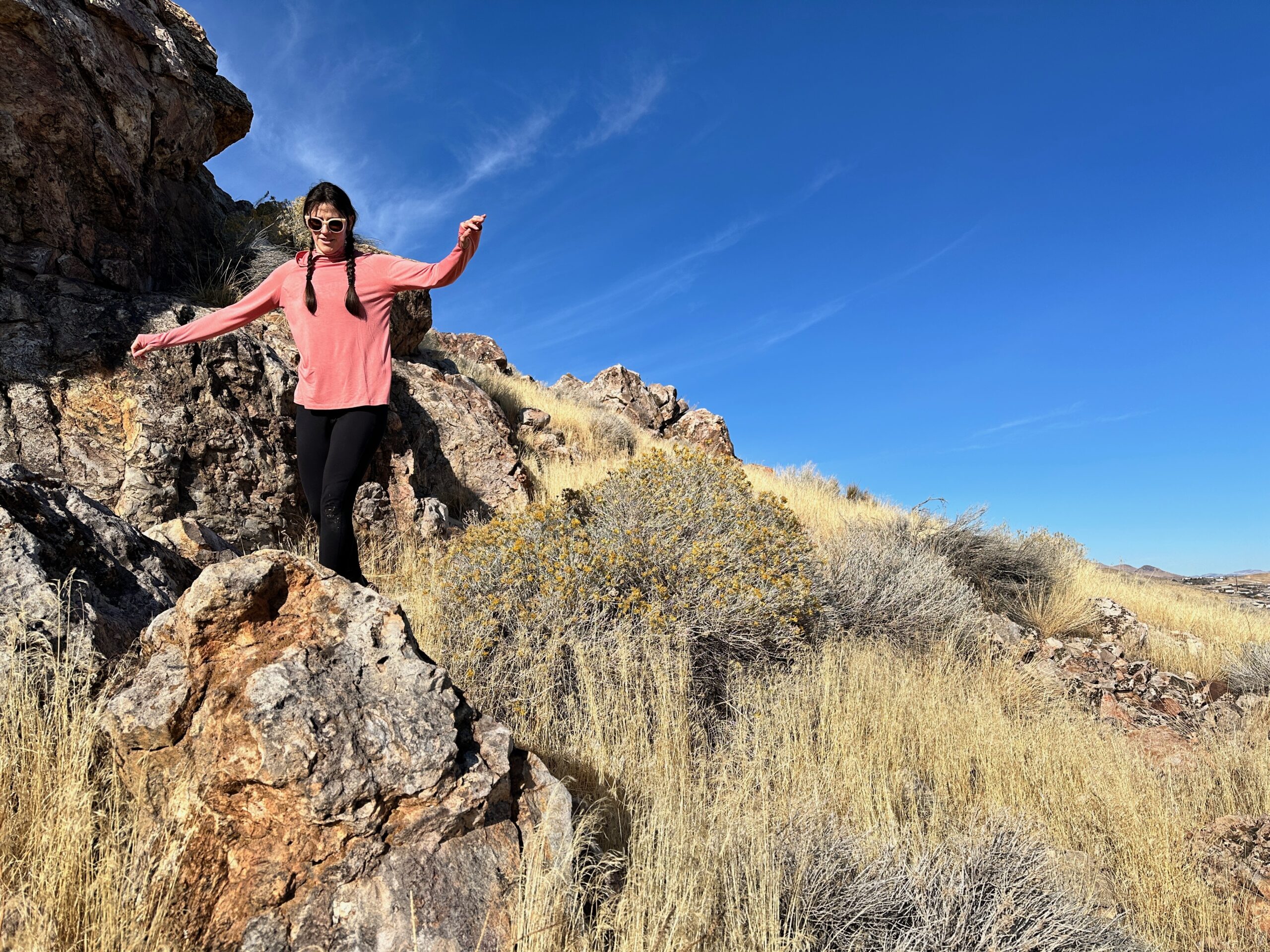 woman hiking with day pack in rocky high desert landscape