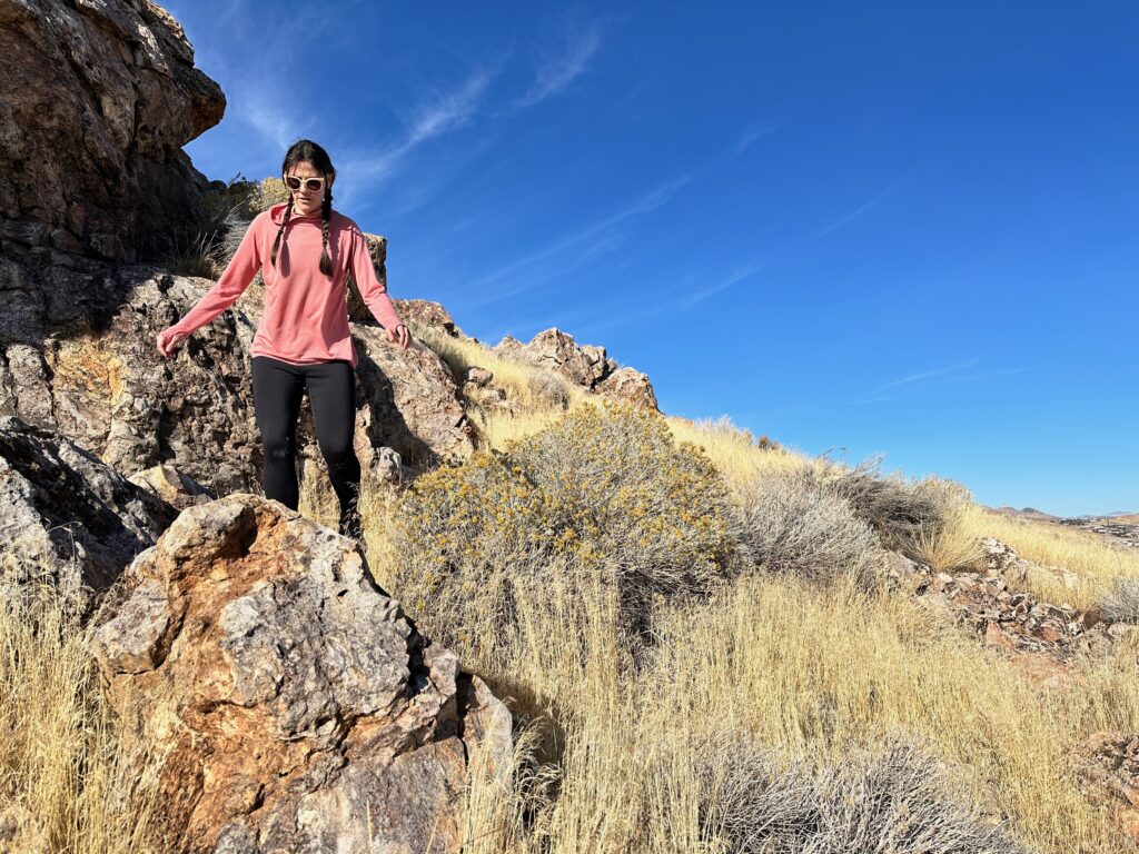 woman hiking with day pack in rocky high desert landscape