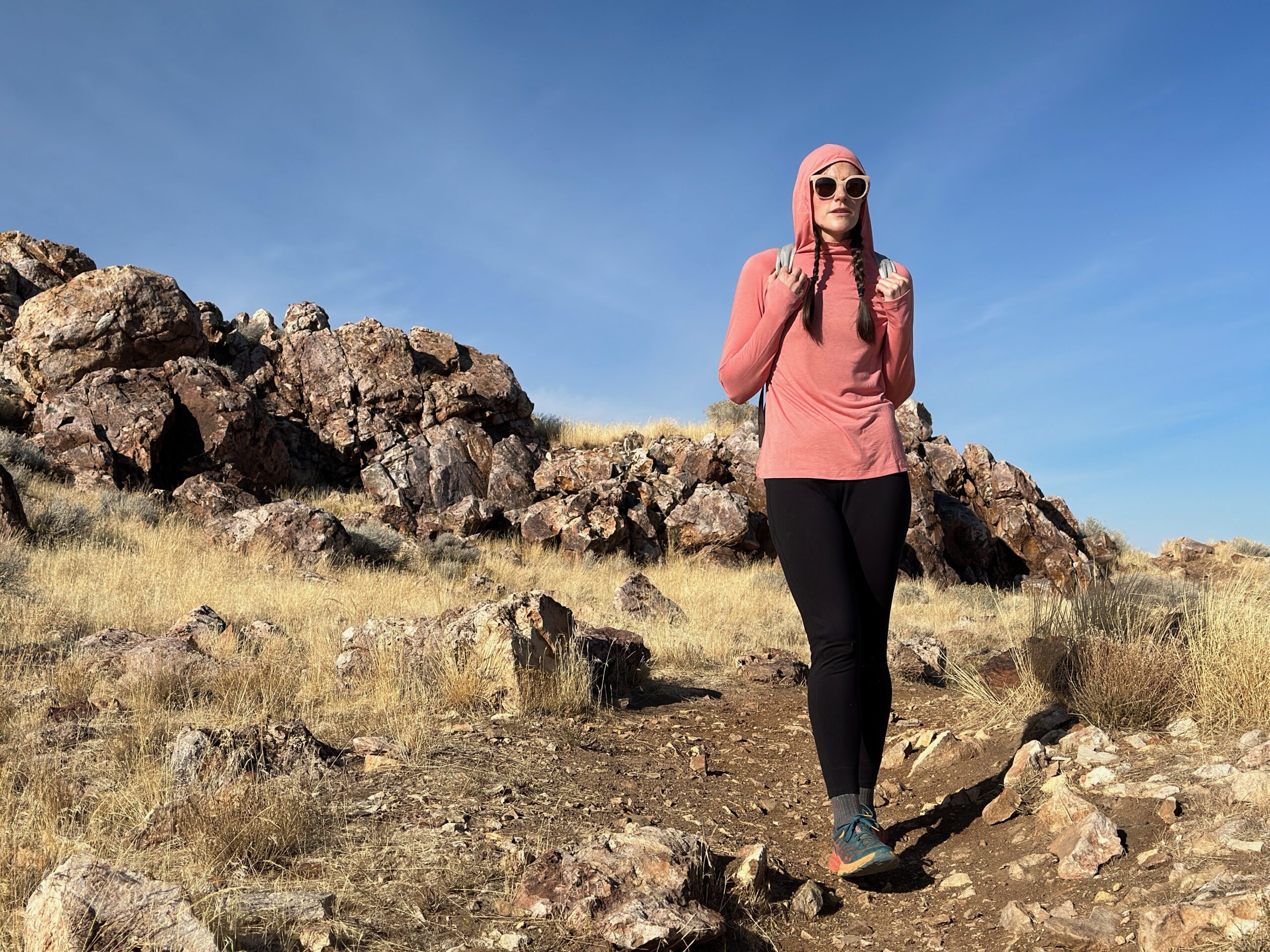 woman hiking with day pack in rocky high desert landscape