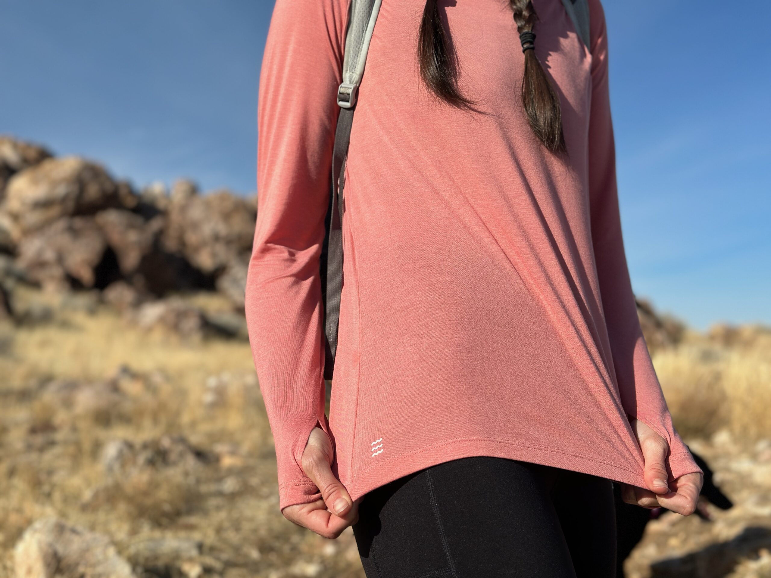 woman hiking with day pack in rocky high desert landscape