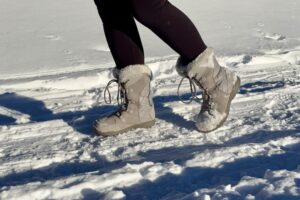 A close up of a person wearing the Ice Maiden boots in the snow.