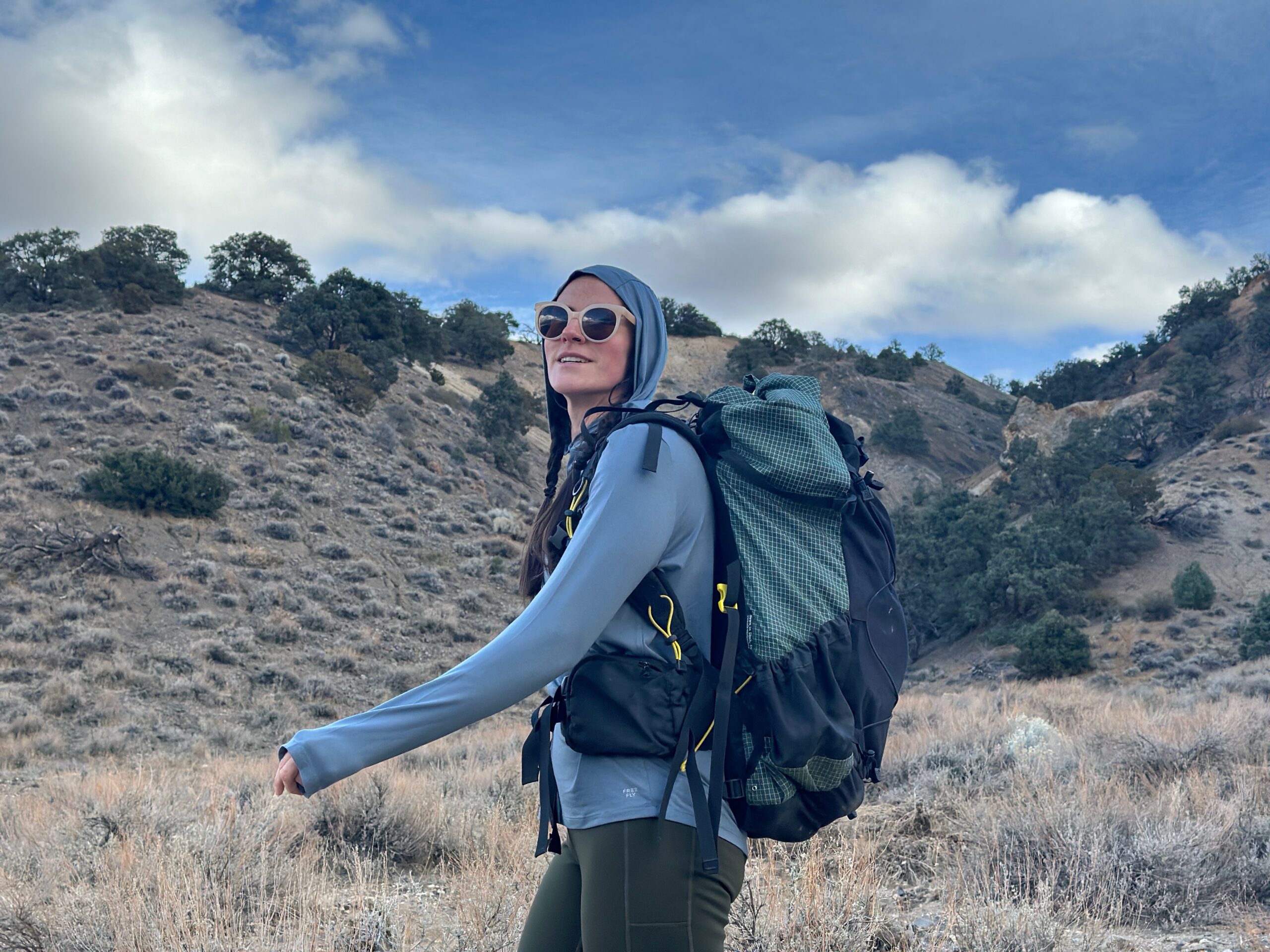 Woman hiking in high desert with backpacking pack on