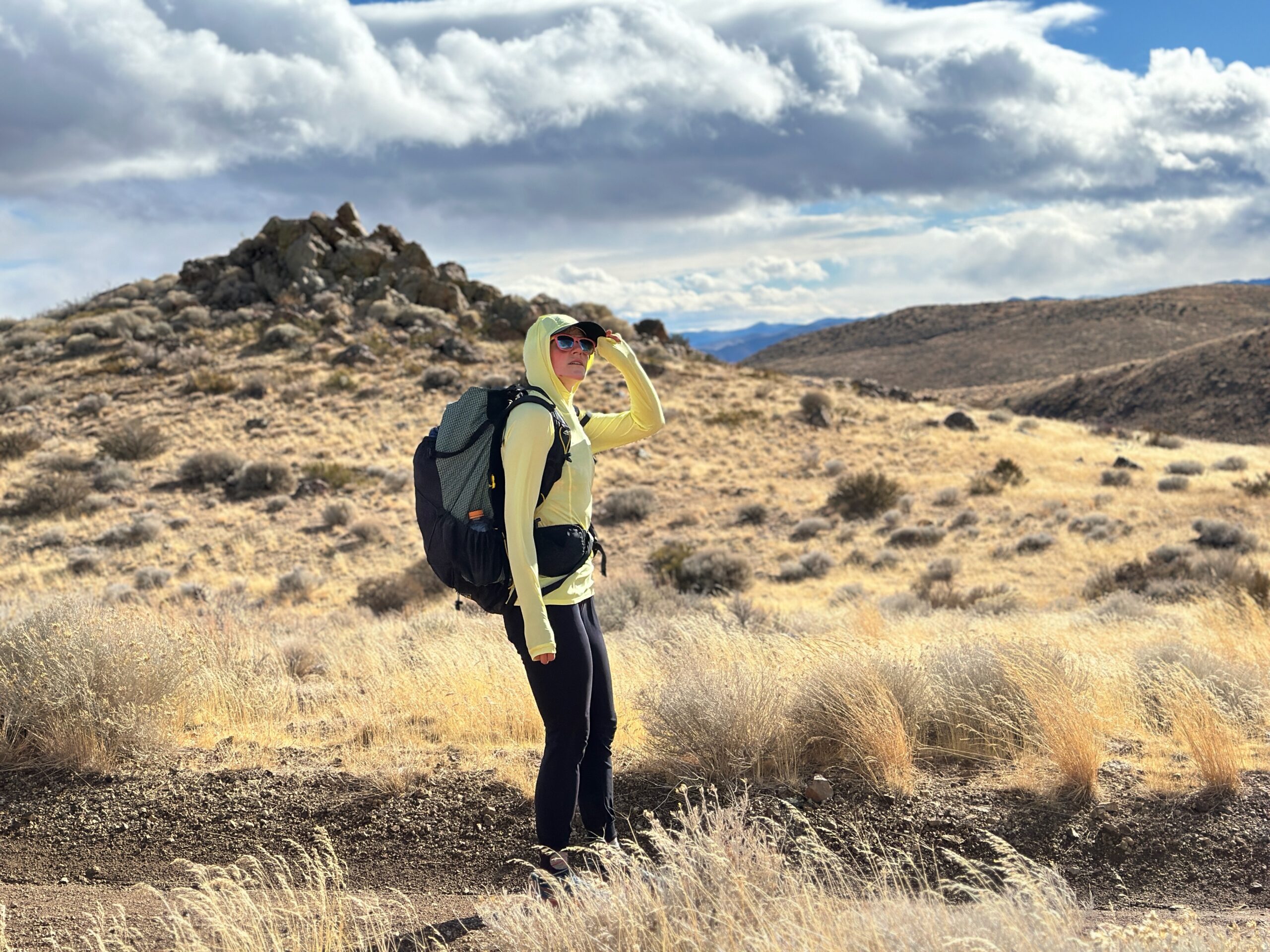 woman hiking with pack on in high desert landscape