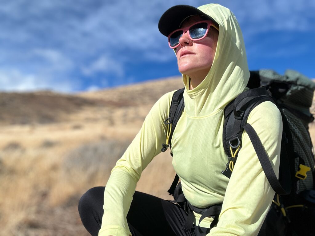 woman hiking with pack on in high desert landscape