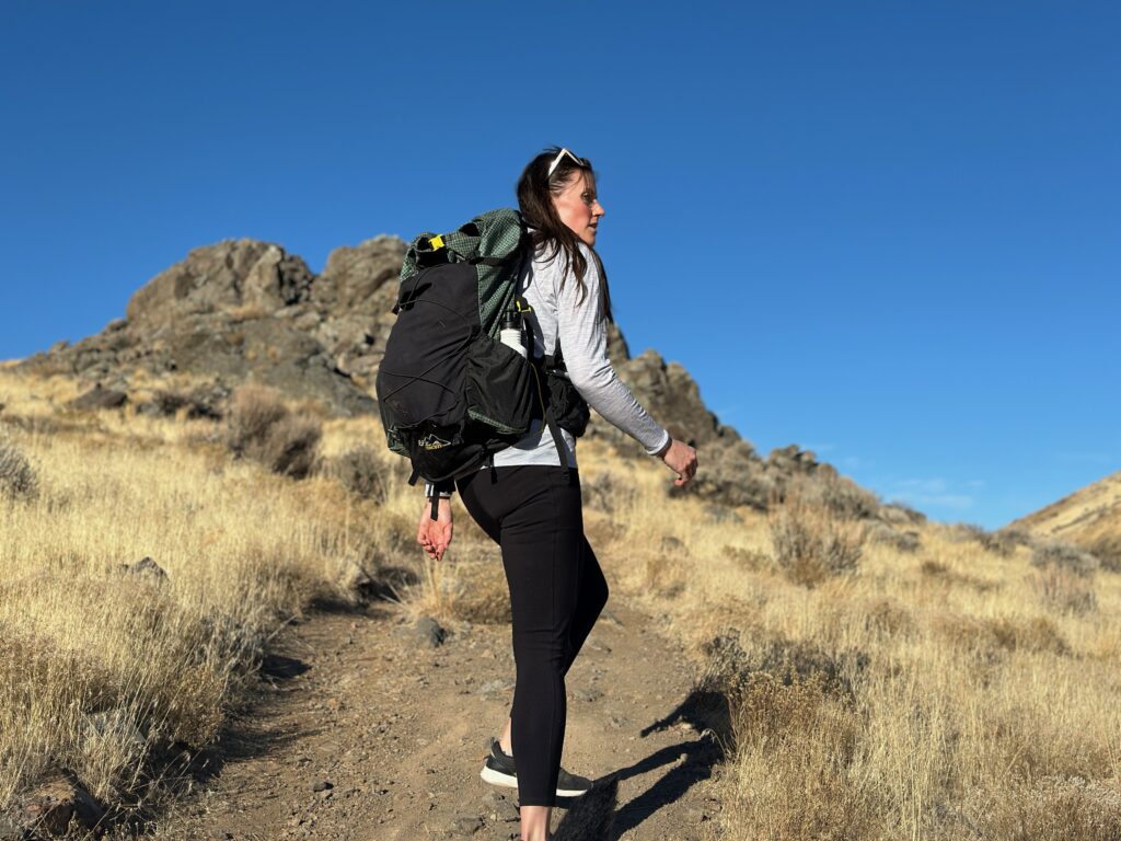 woman hiking with backpacking pack on through high desert