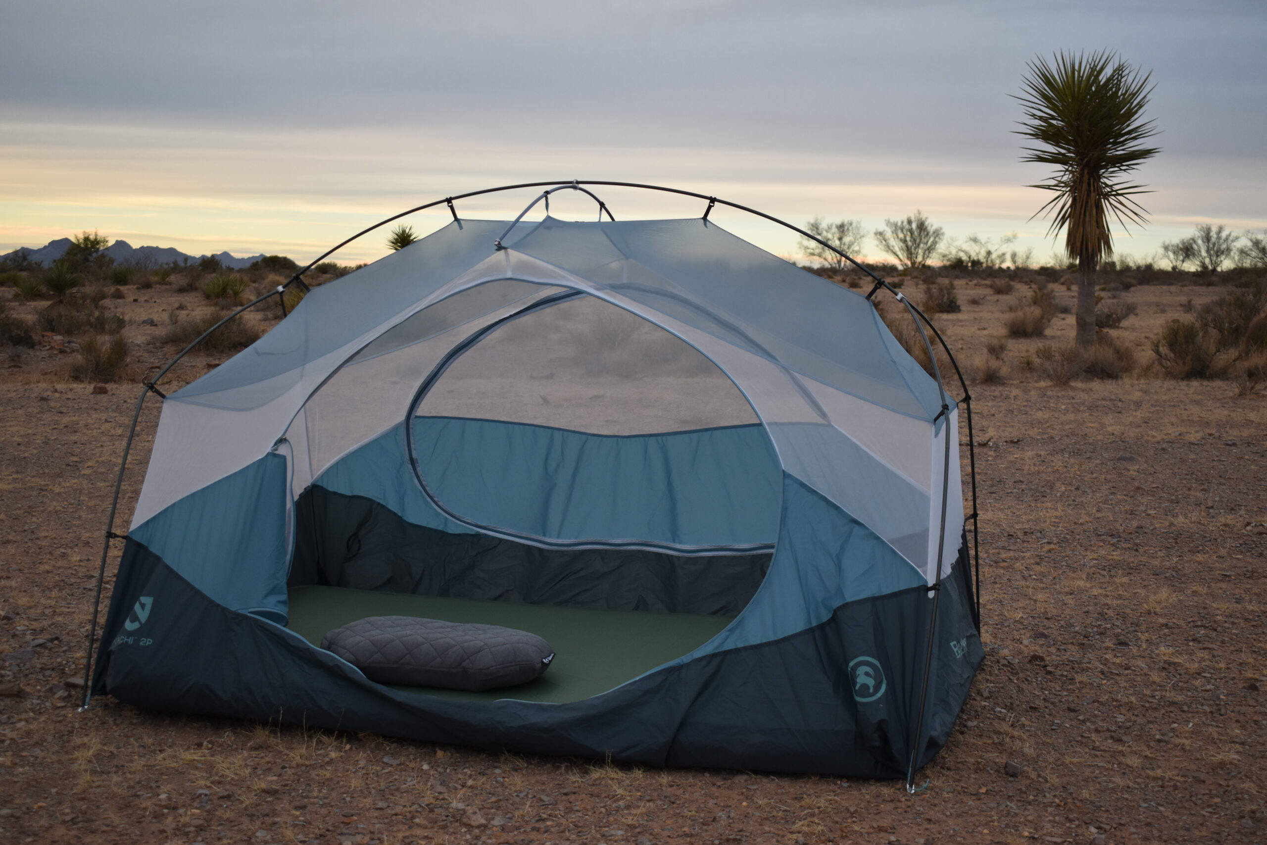 The Klymit LUXE Pillow centered in an open tent pitched in the desert next to a Joshua Tree