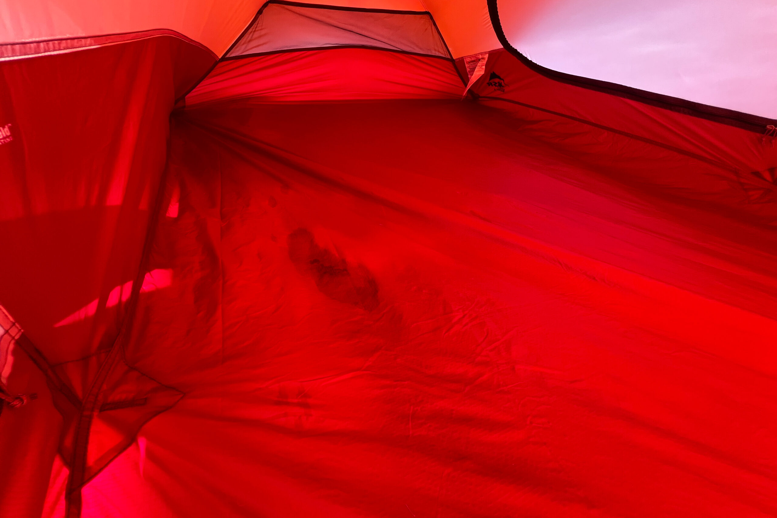 Interior view of the MSR Access 2 tent showcasing the bright red fabric and spacious layout.