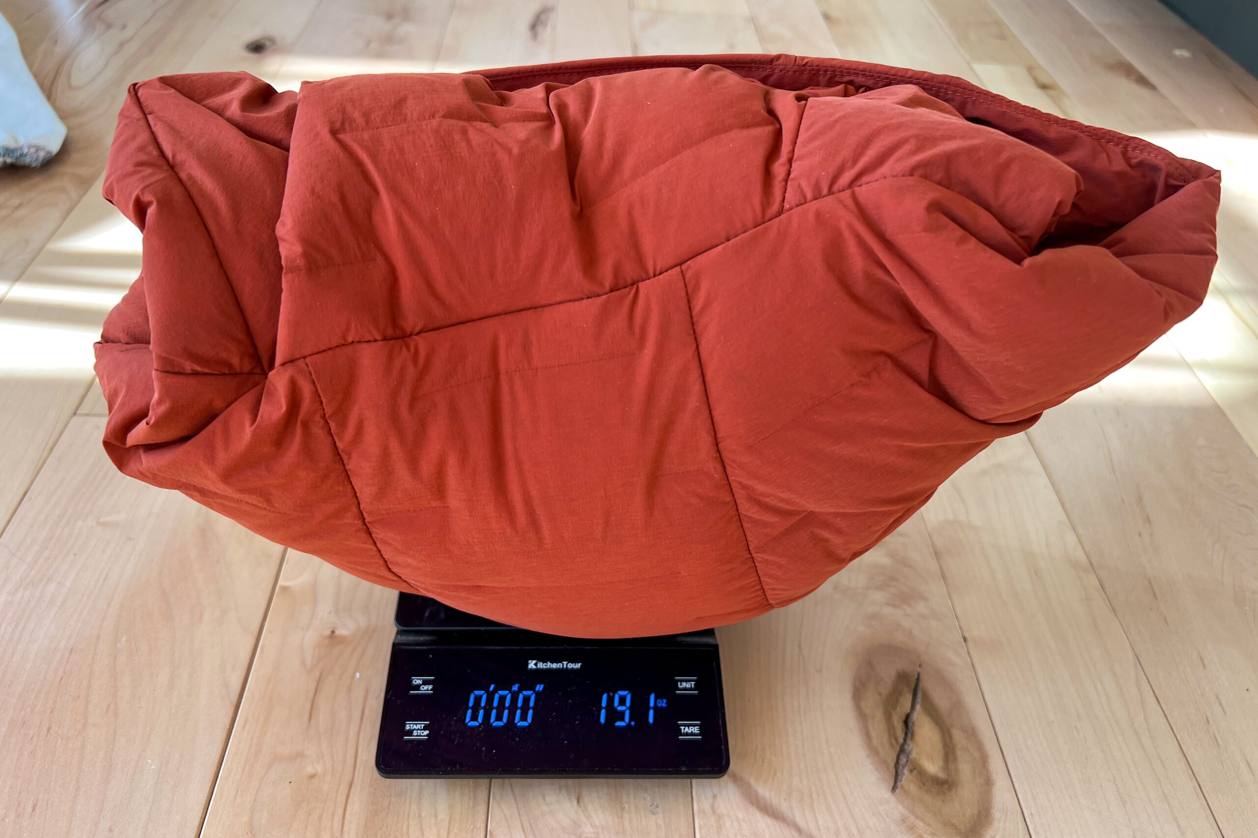 A Mountain Hardwear StretchDown Hoody sitting on a digital scale, displaying a weight of 19.1 ounces.