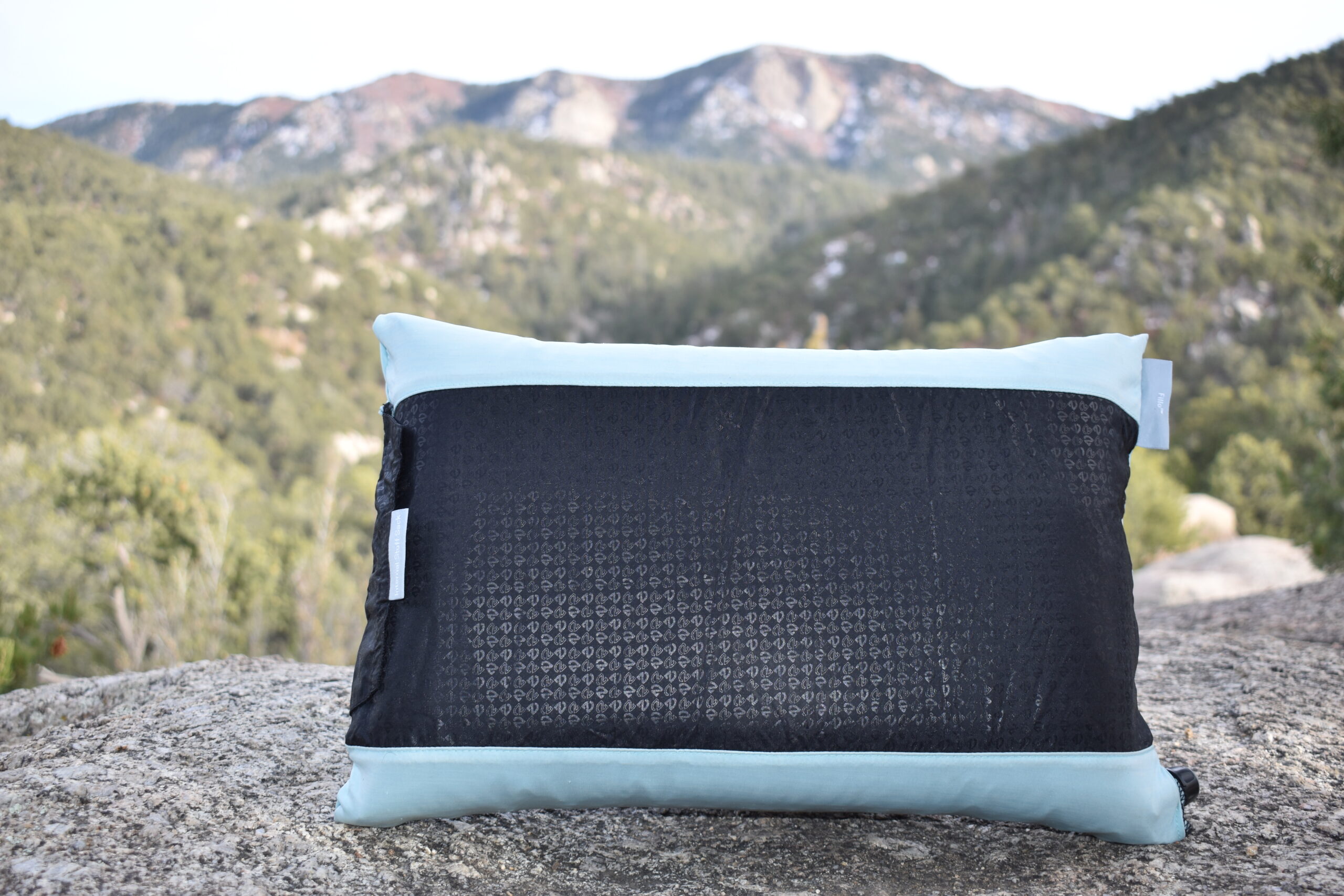 Close up of NEMO Fillo camp pillow with mountains blurred in the background