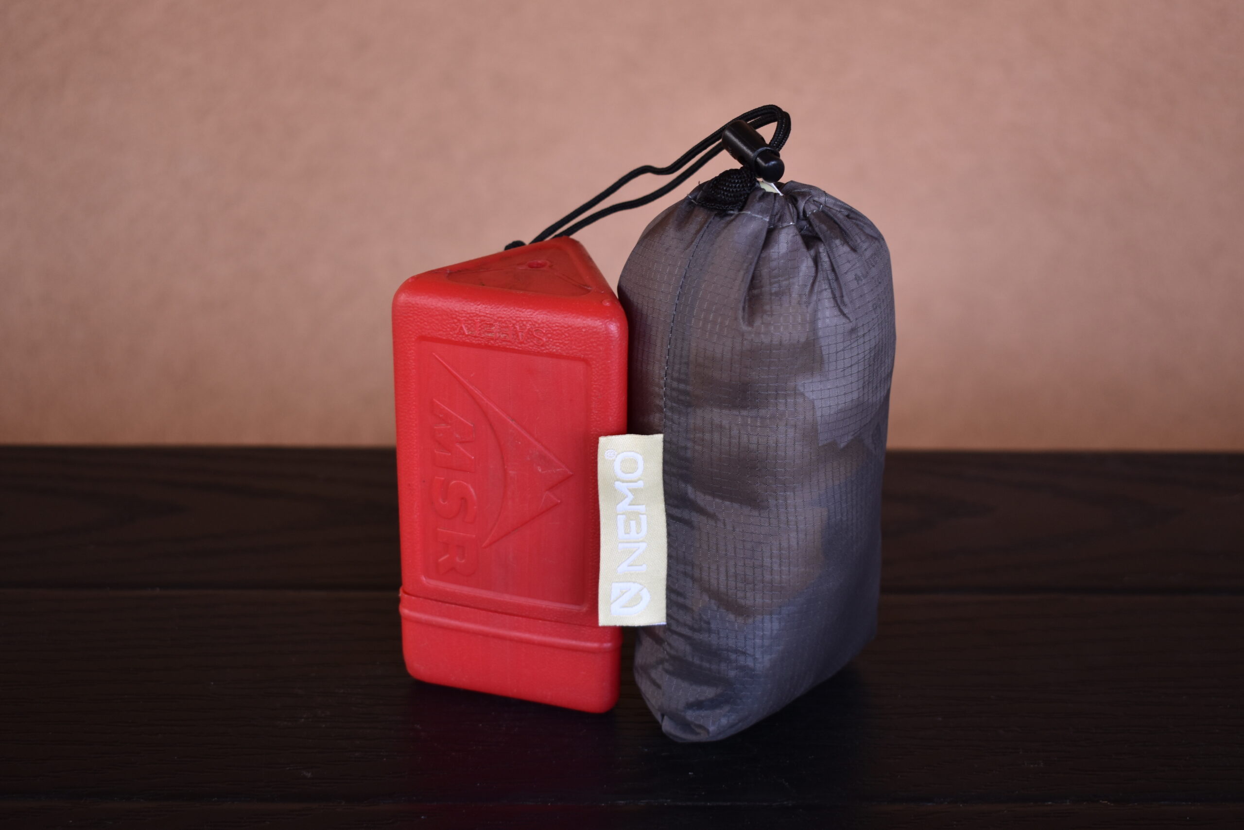 The MSR Pocket Rocket backpacking stove (left) sits next to the NEMO Fillo Elite Luxury Pillow (right), which is similar in size