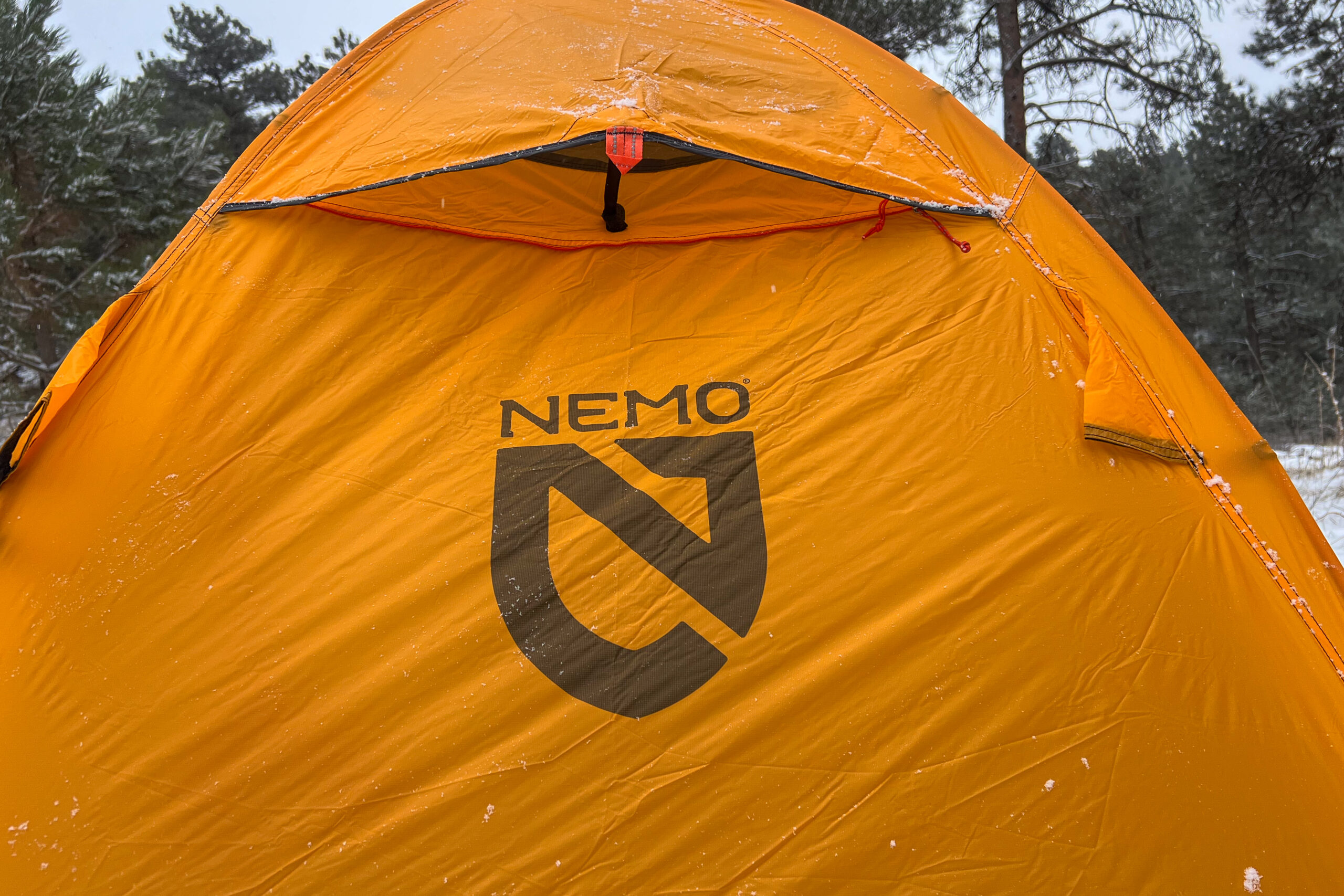 Close-up of the rear vent on the Nemo Kunai 2 tent showing the Nemo logo and snow on the fabric.