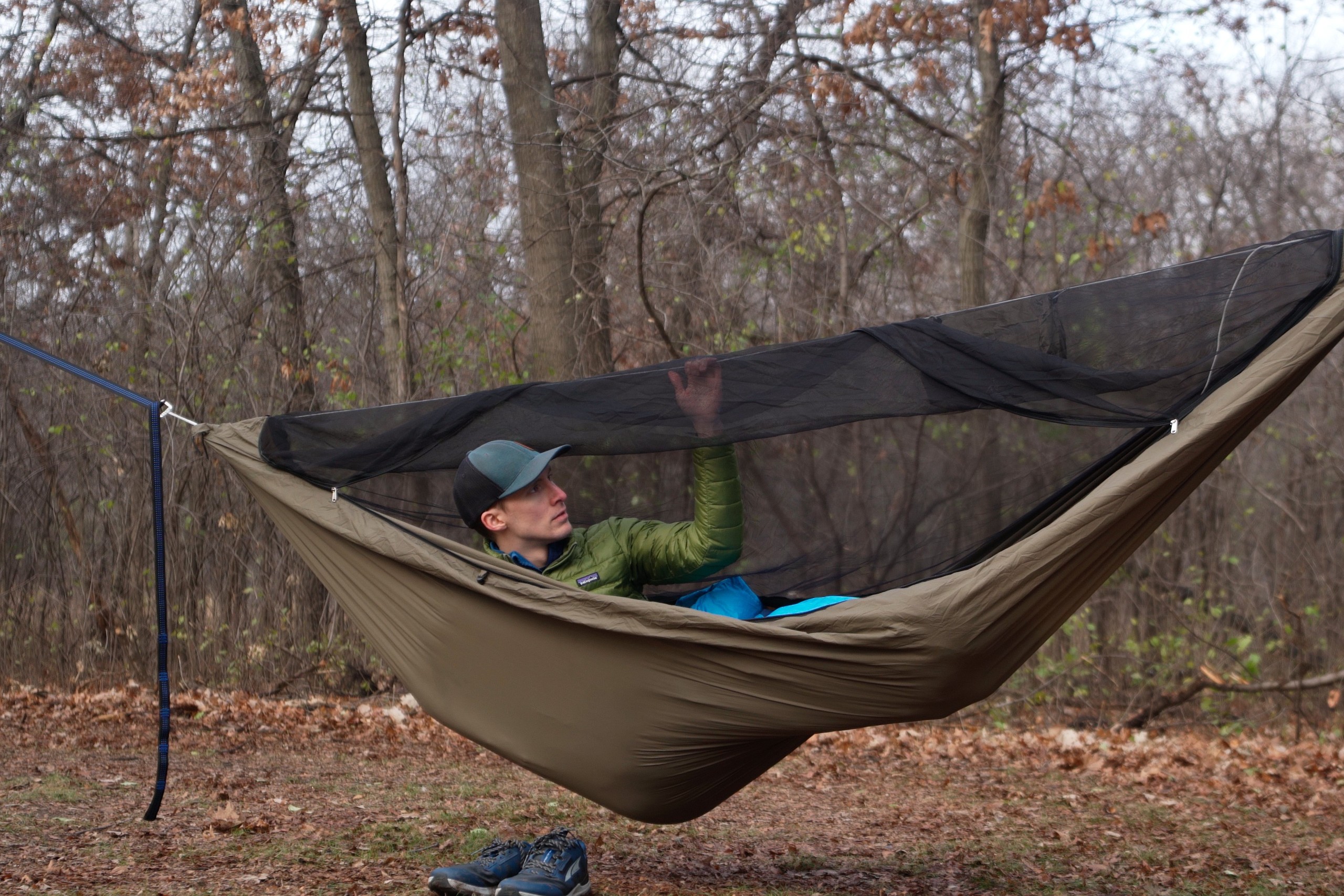 a man lies in a hammock with a hand on the ridgeline