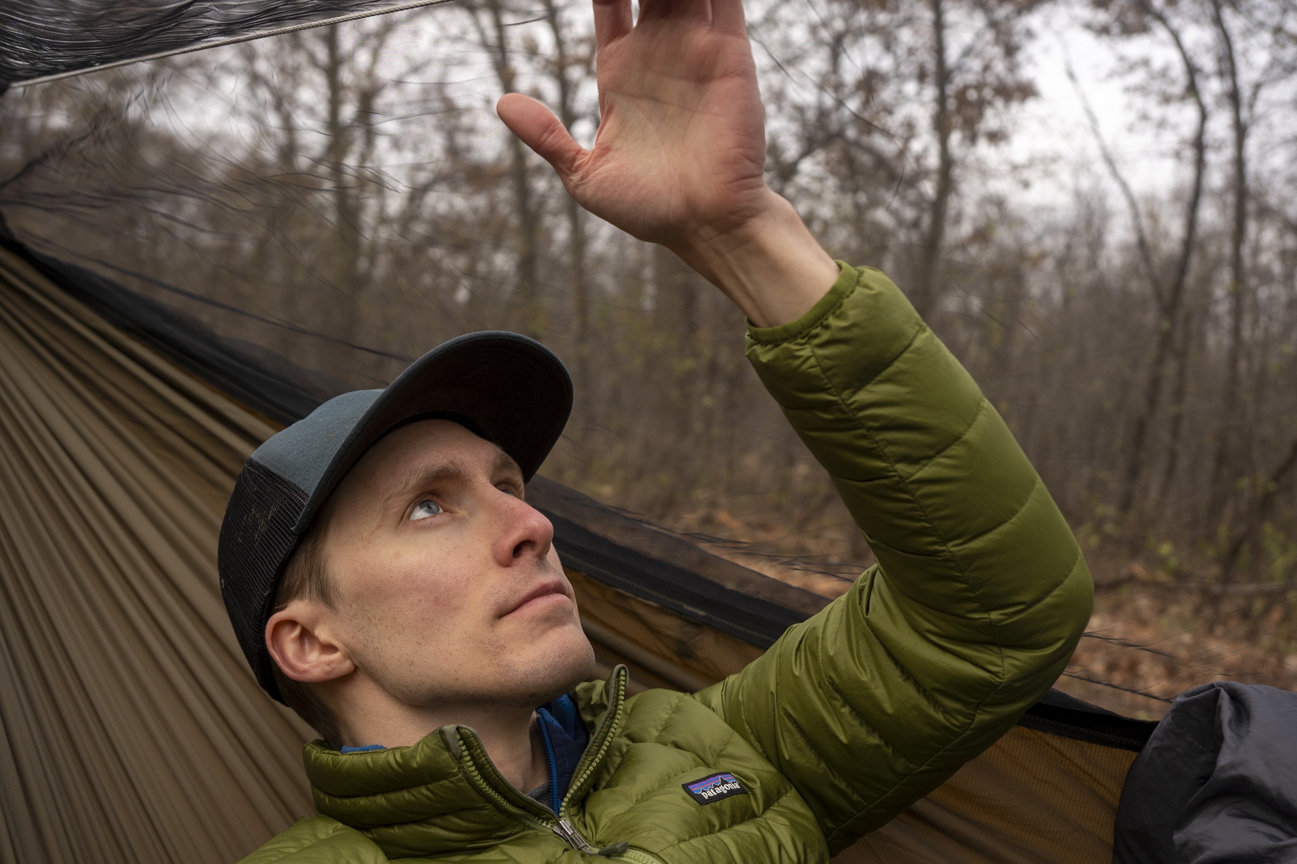 a man sits in a hammock and rests a hand on the ridgeline