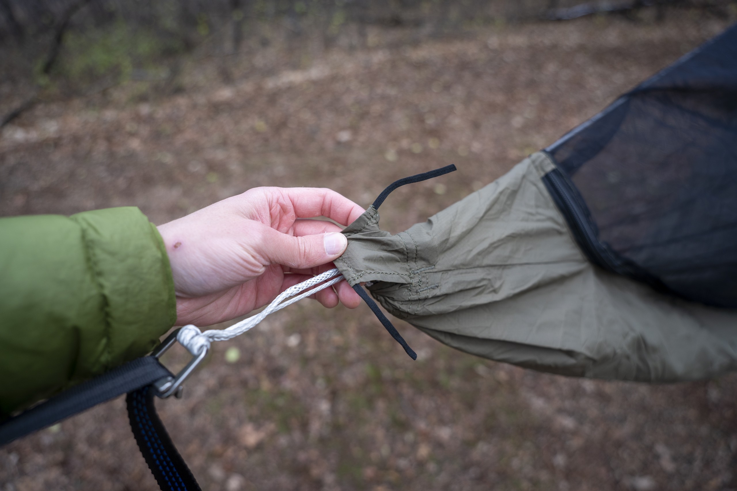 a hand holds the end of a hammock