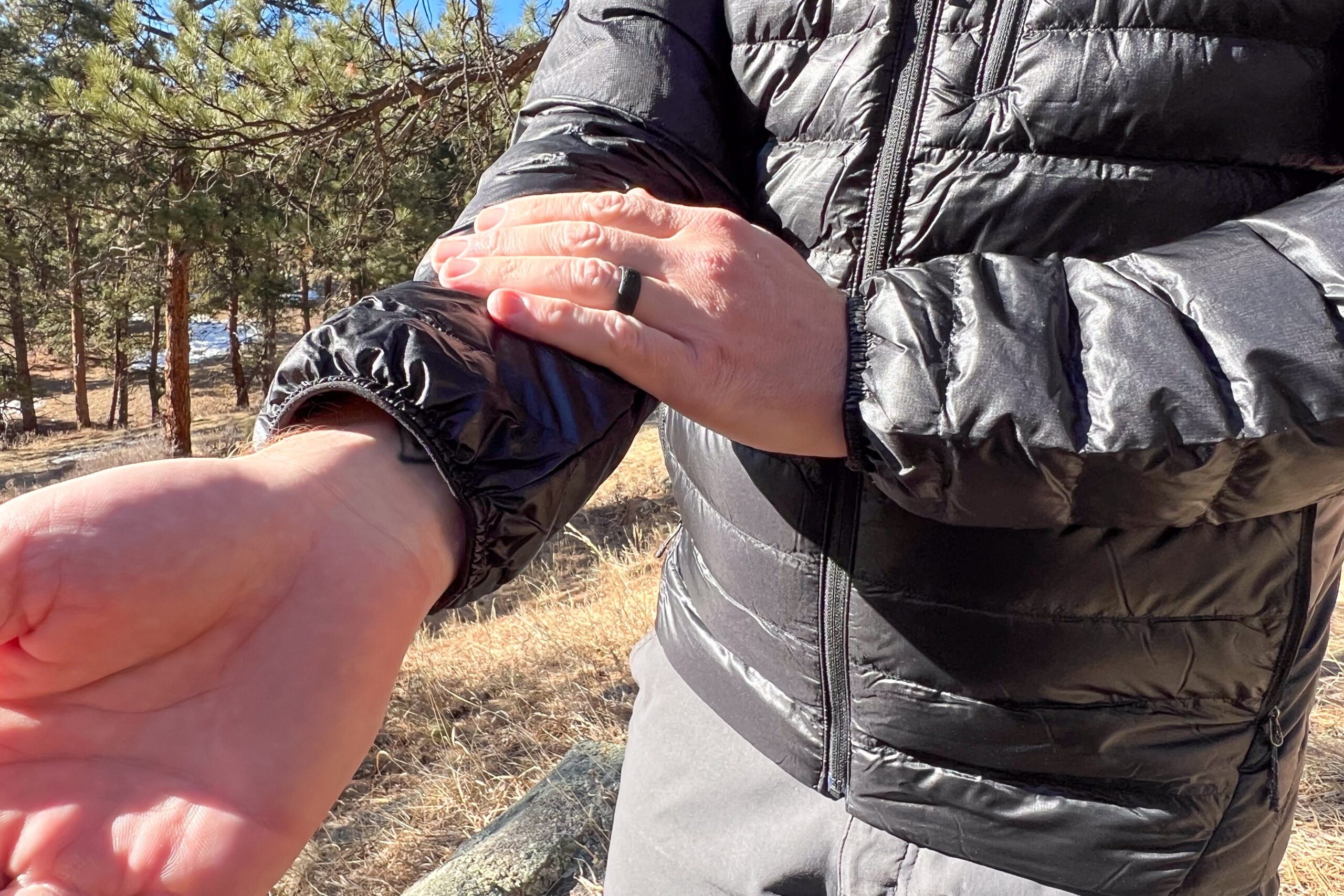 Close-up of the Outdoor Research Helium Down Hoody's elastic cuffs being adjusted, highlighting the snug fit around the wrist.