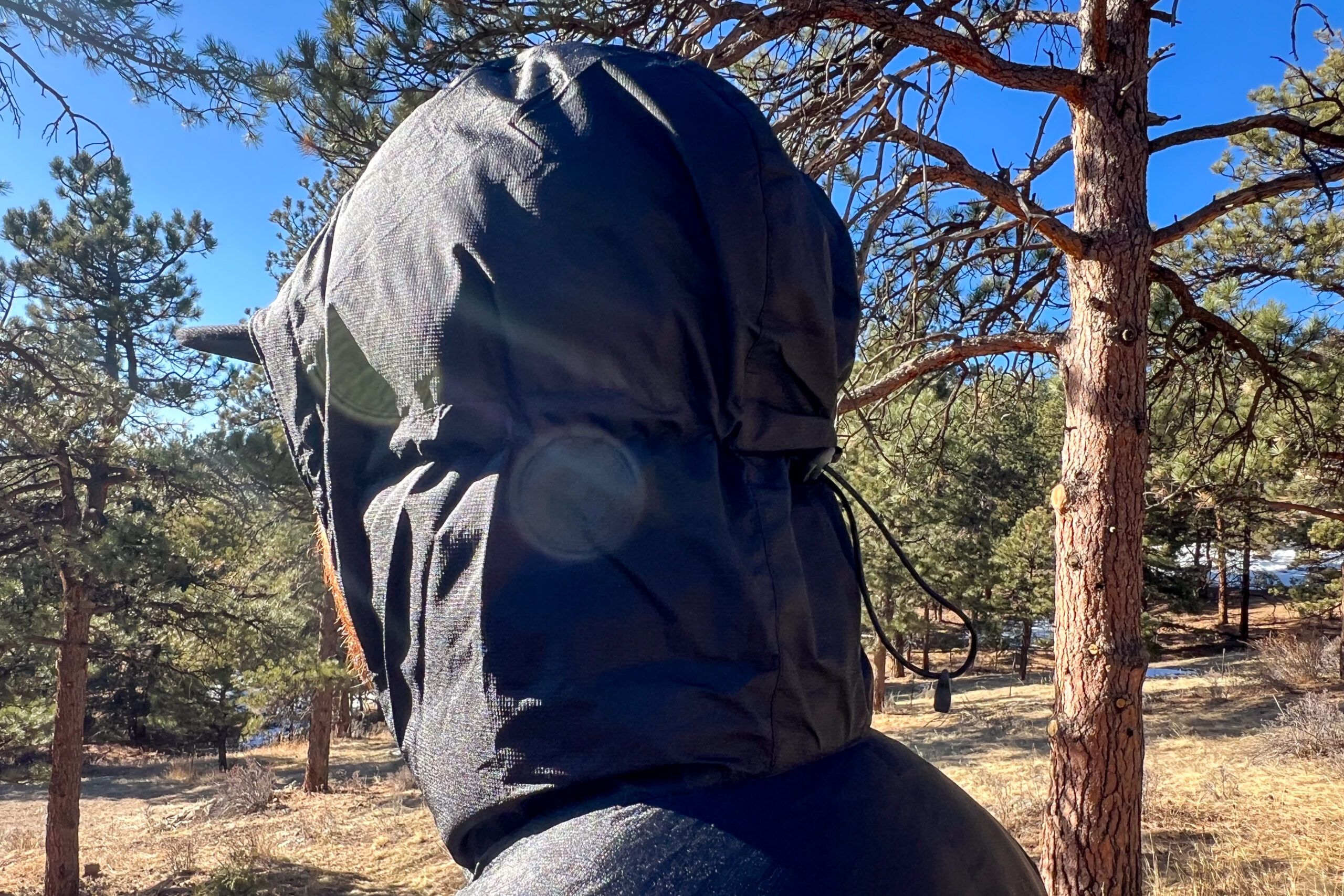 Close-up side view of the Outdoor Research Helium Down Hoody’s hood, showing its coverage and drawcord adjustment.