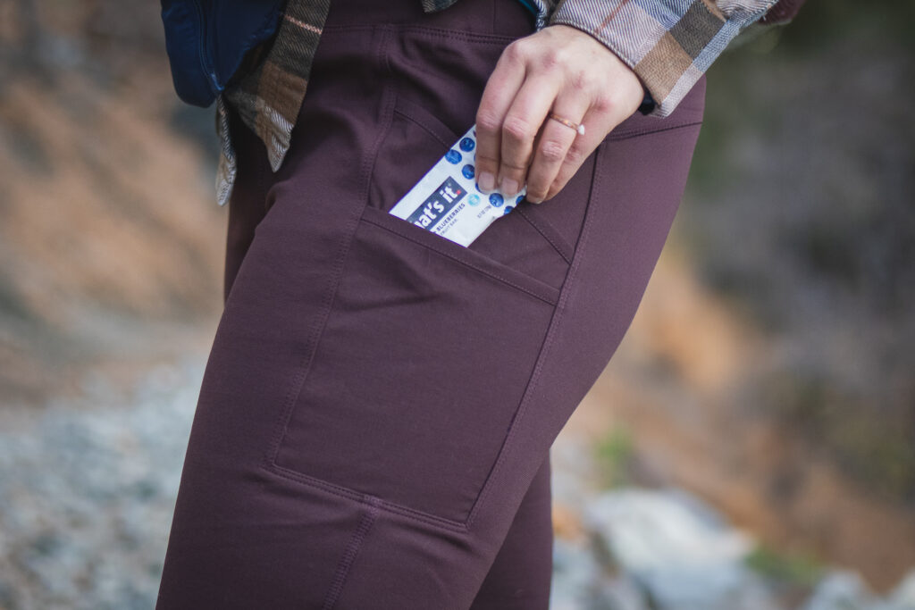 Woman on a hiking trail in rugged dark brown leggings.