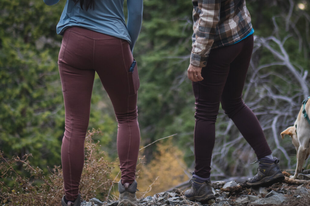 Two people on hiking rail, one in pastel pink leggings and another in dark brown leggings.