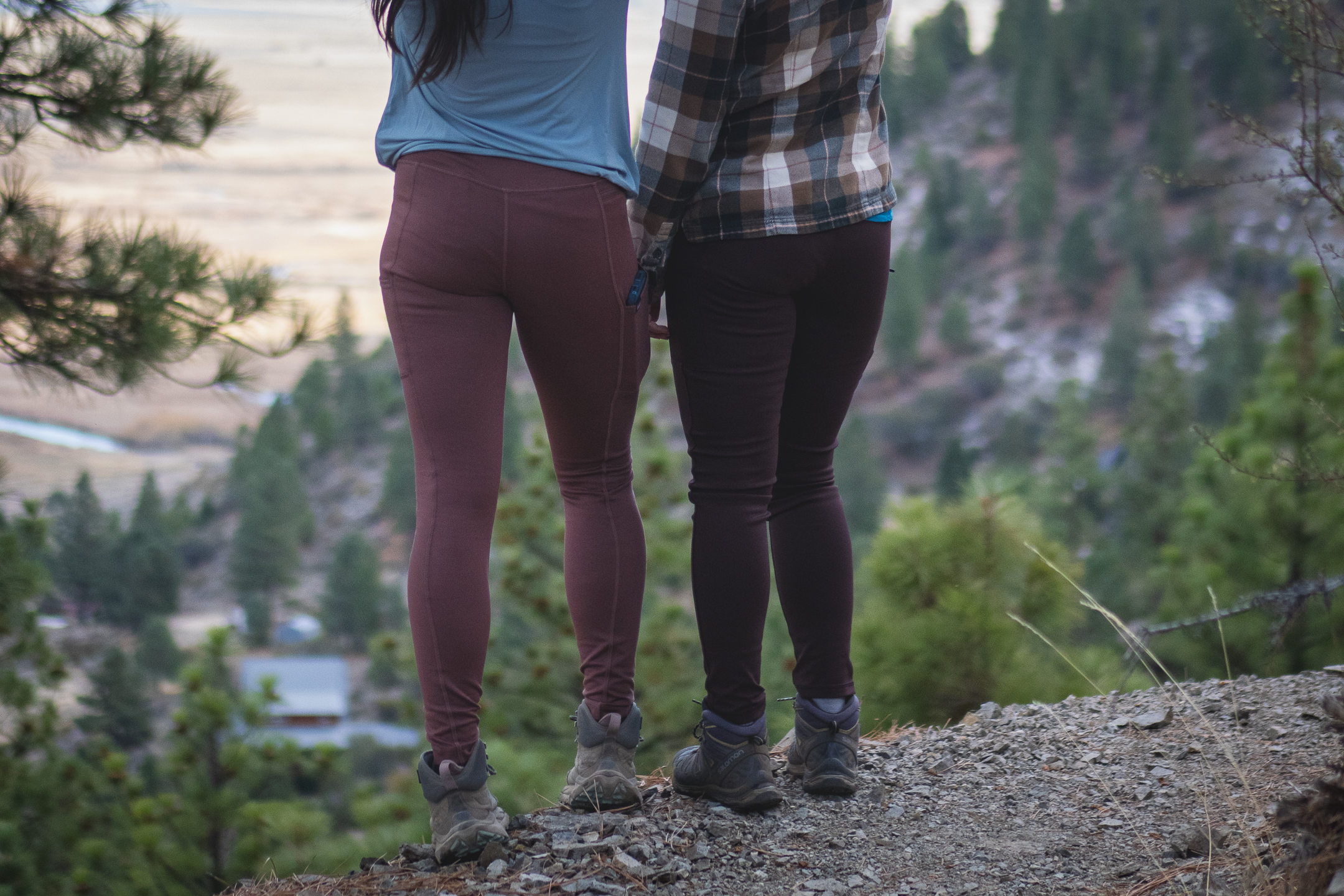 Two people on hiking rail, one in pastel pink leggings and another in dark brown leggings.