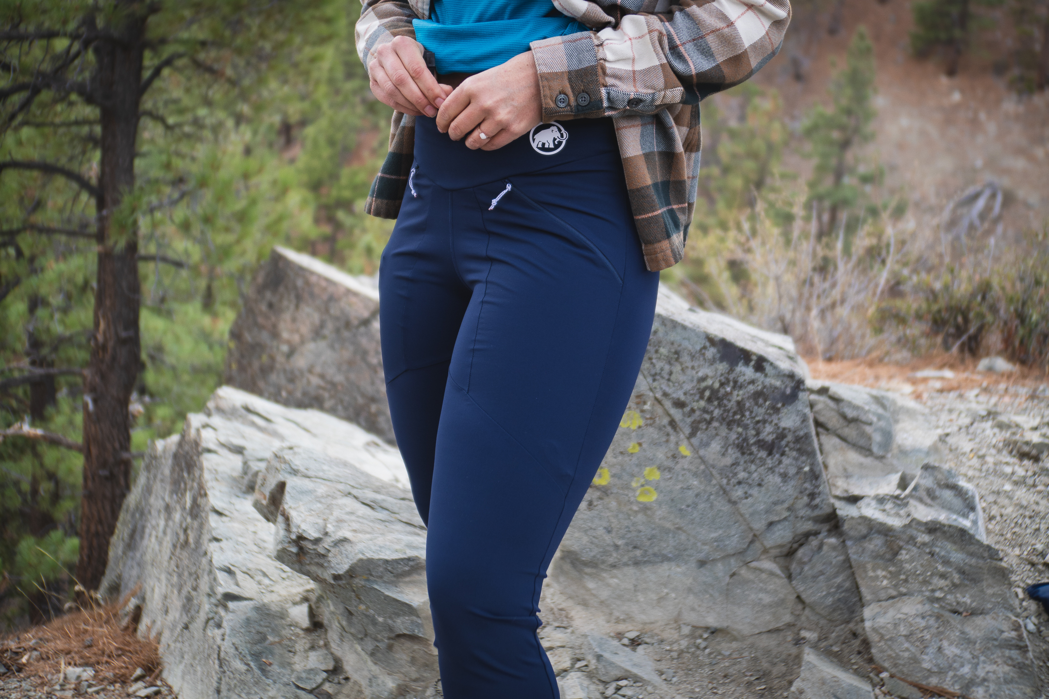 Woman hiking in dark blue athletic leggings.