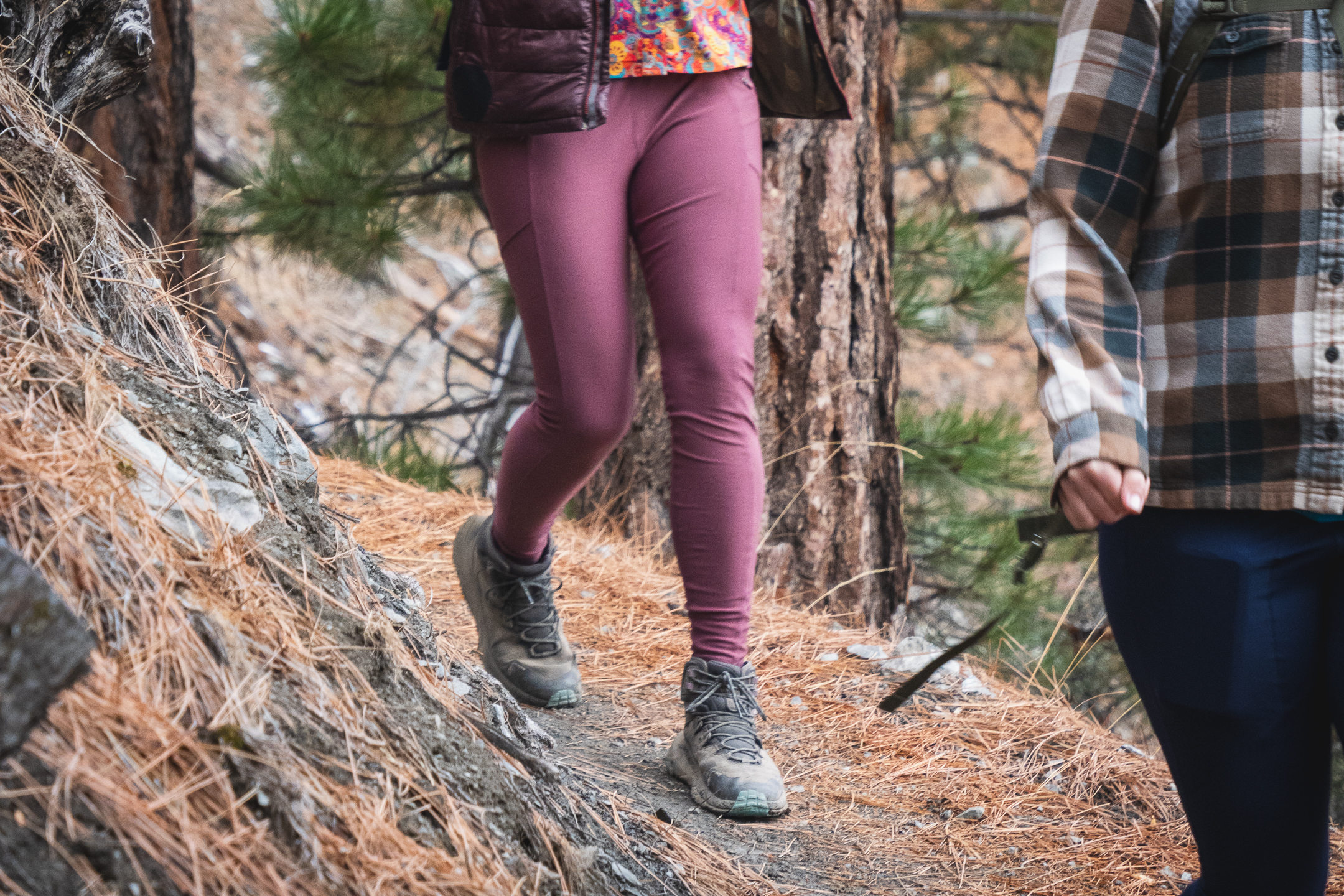 person hiking down a trail, in pastel pink leggings close-up on just the bottom half