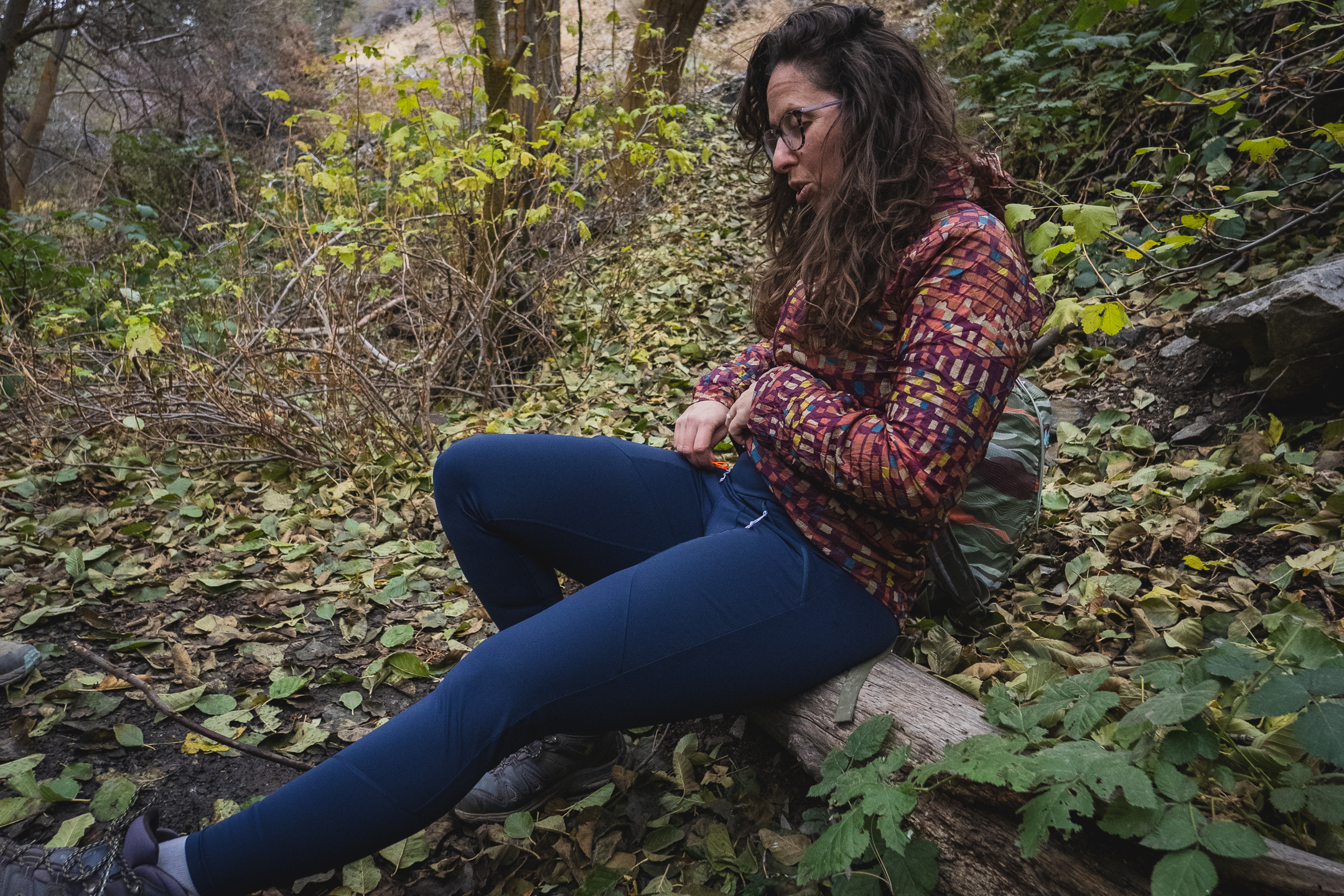 Woman hiking in dark blue athletic leggings.