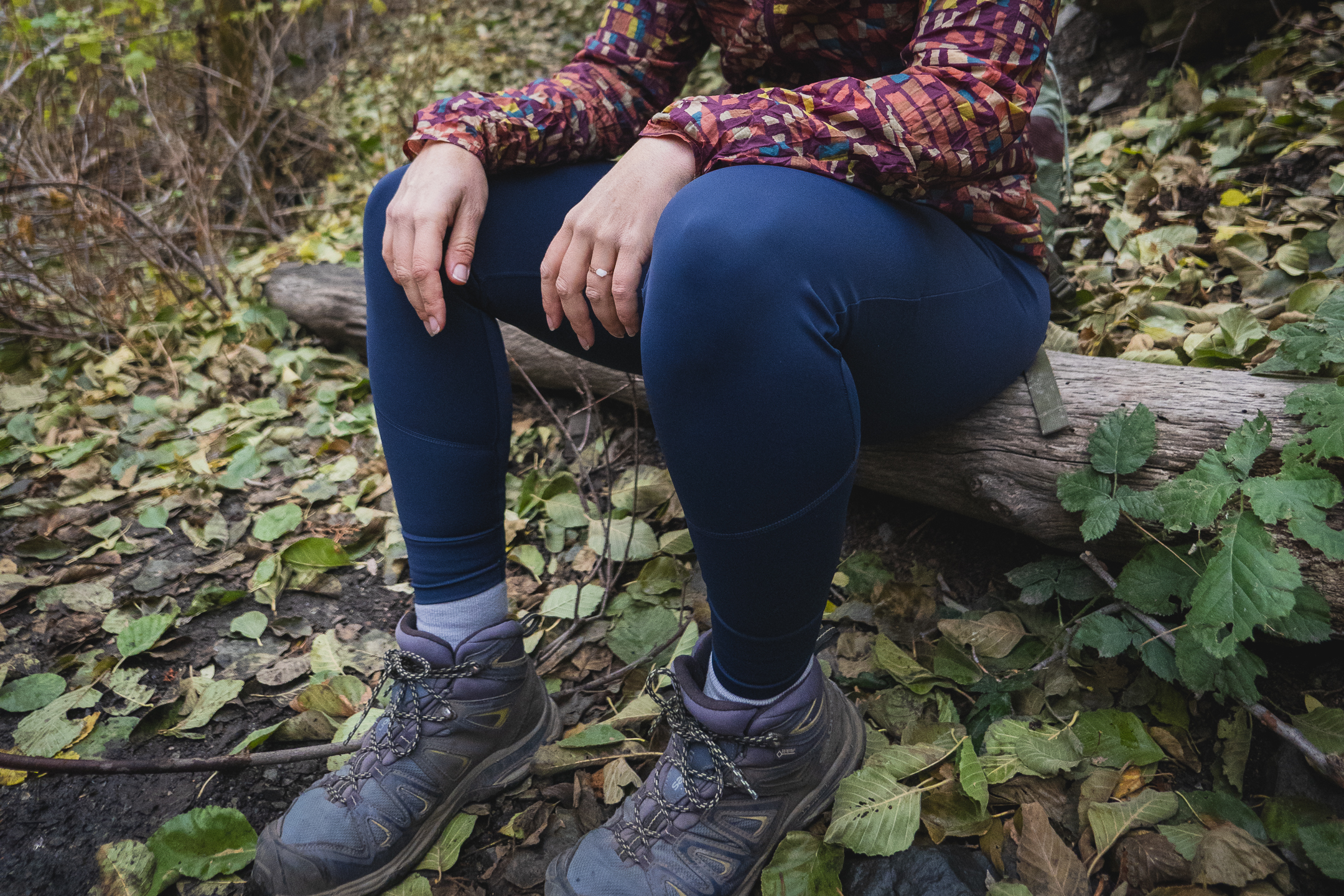 Woman hiking in dark blue athletic leggings.