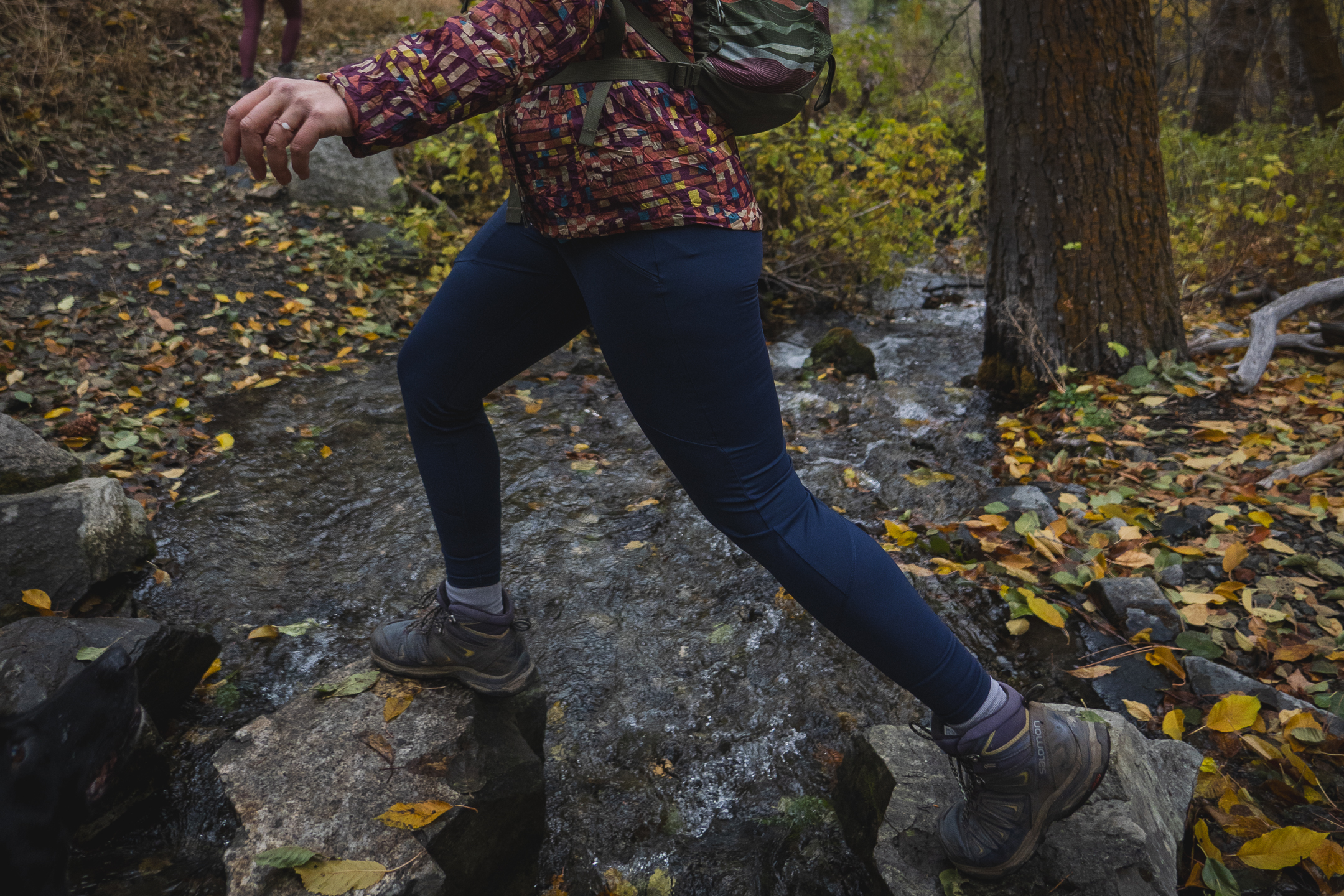 Woman hiking in dark blue athletic leggings.