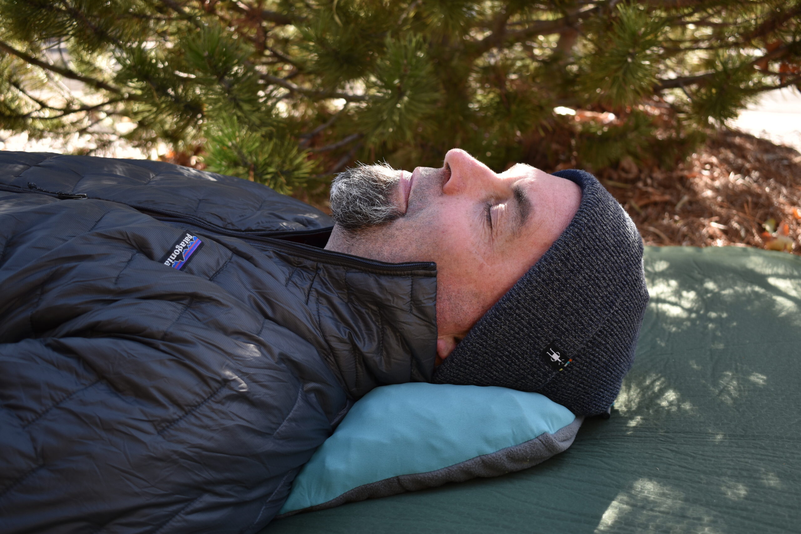 The REI Trailmade Mummy Bag Pillow is barely visible beneath the neck of our gear analyst