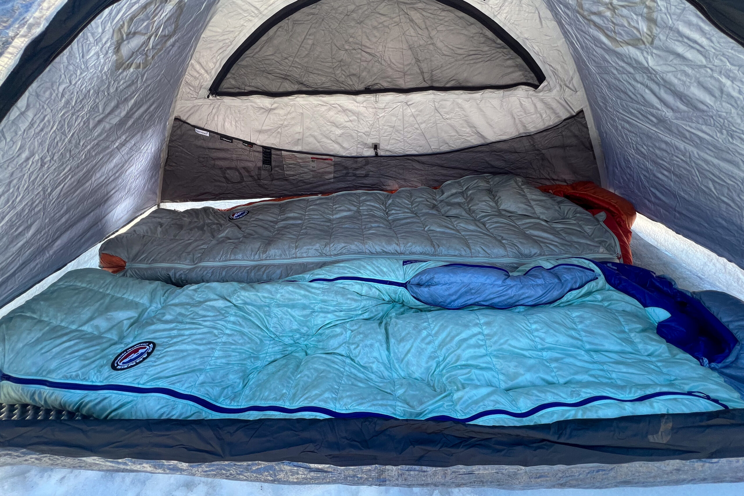 The inside view of the Samaya 2.0 tent, showing two sleeping bags arranged neatly and a large mesh vent on the ceiling for ventilation.