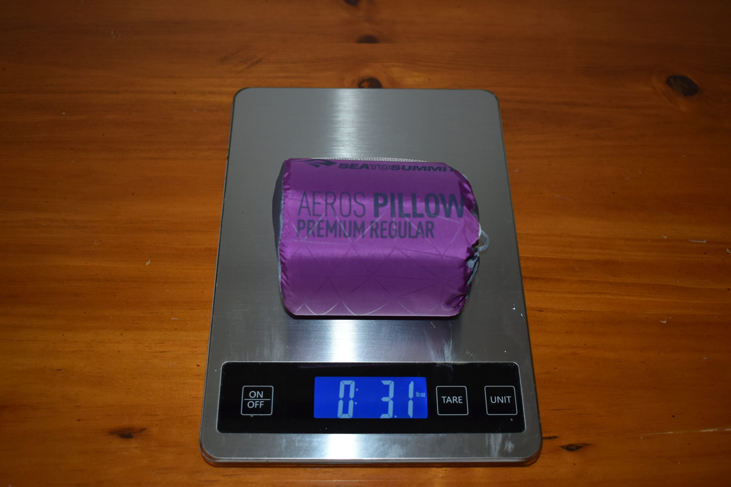 Packed pillow sitting on a kitchen scale that displays a weight of 3.1 ounces