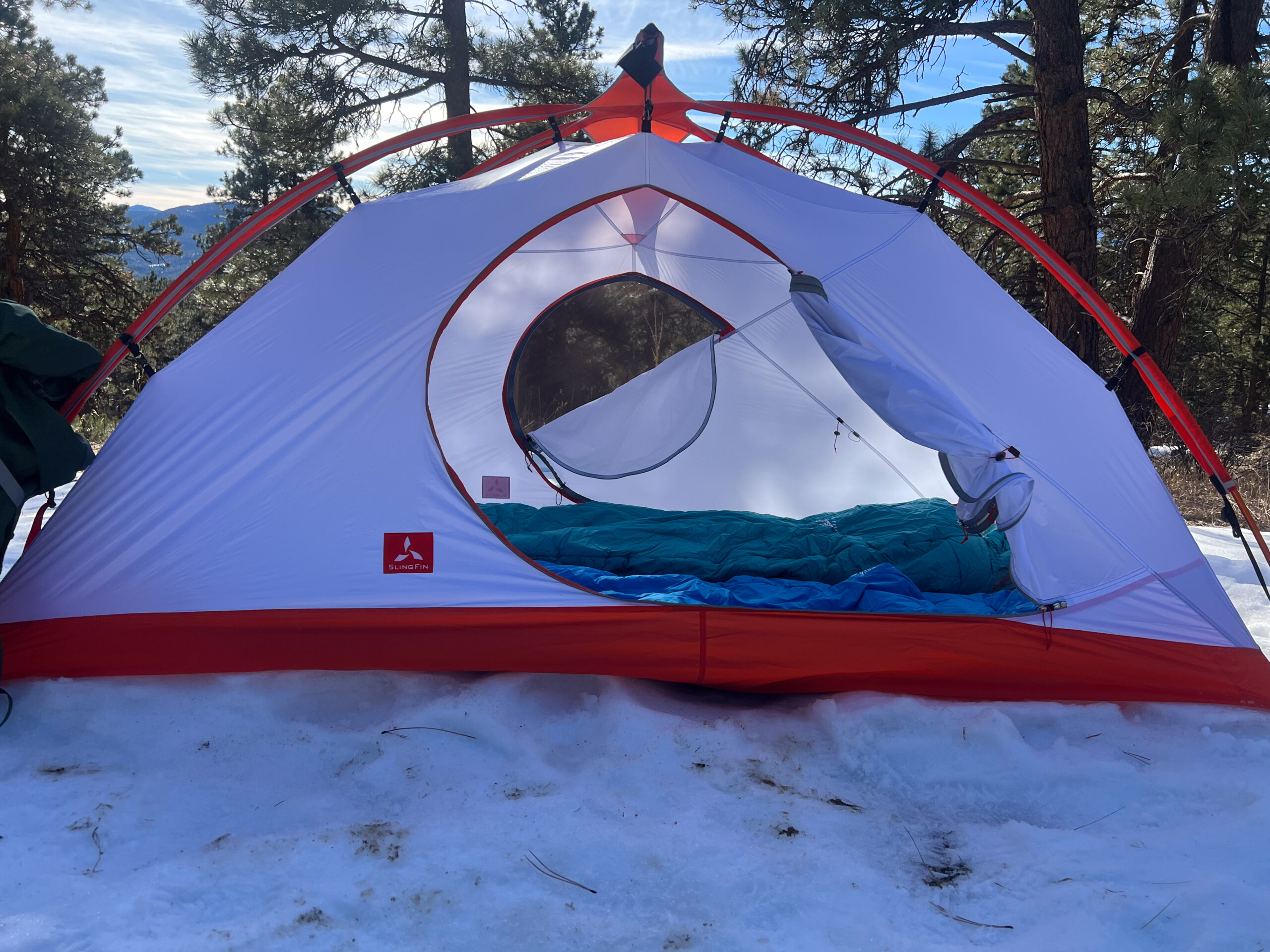 A show of a tent from the side and the door is open an rolled to the side.