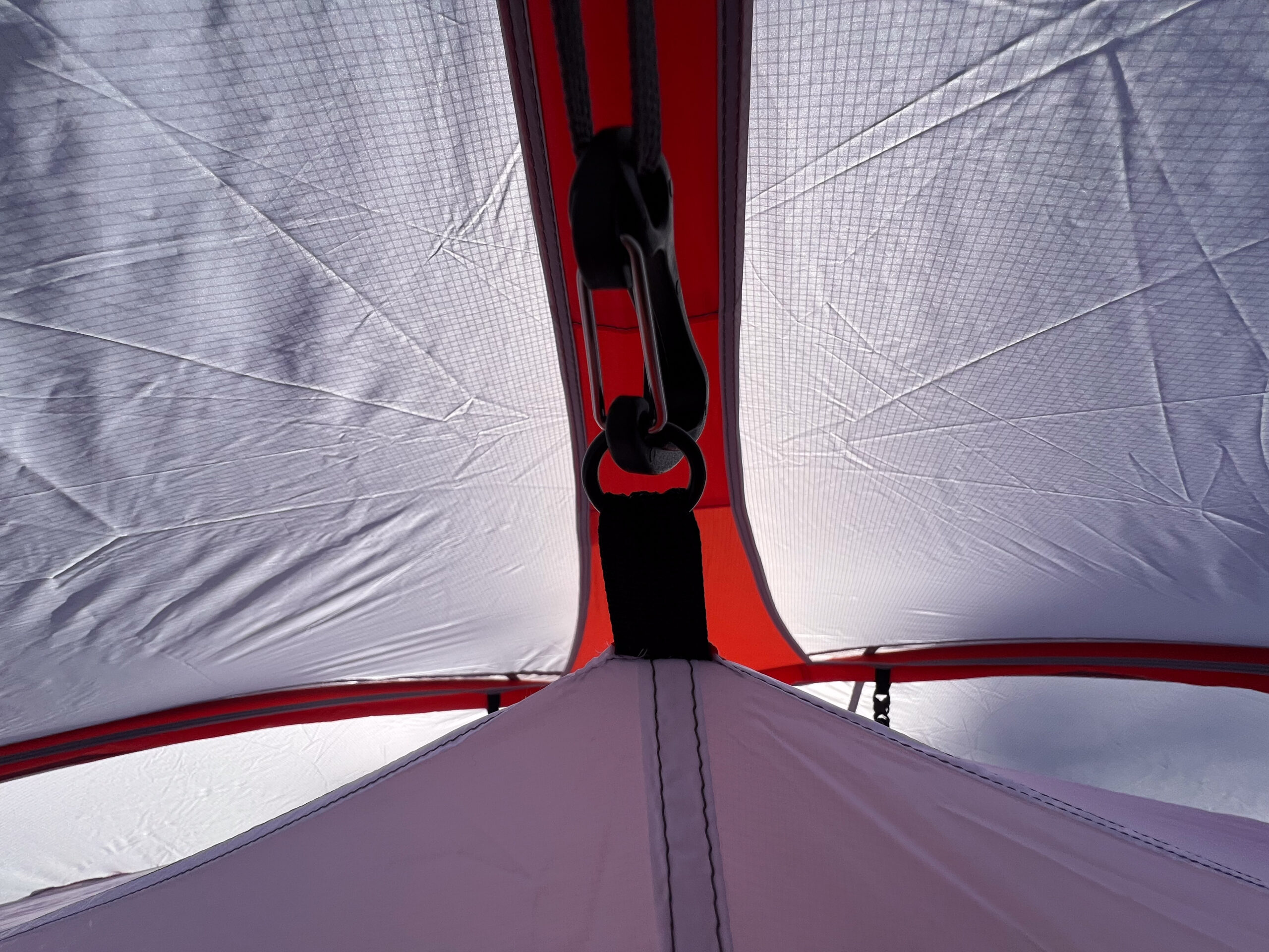 SlingFin CrossBow 2 tent with an open door revealing its interior in a snow-covered forest.