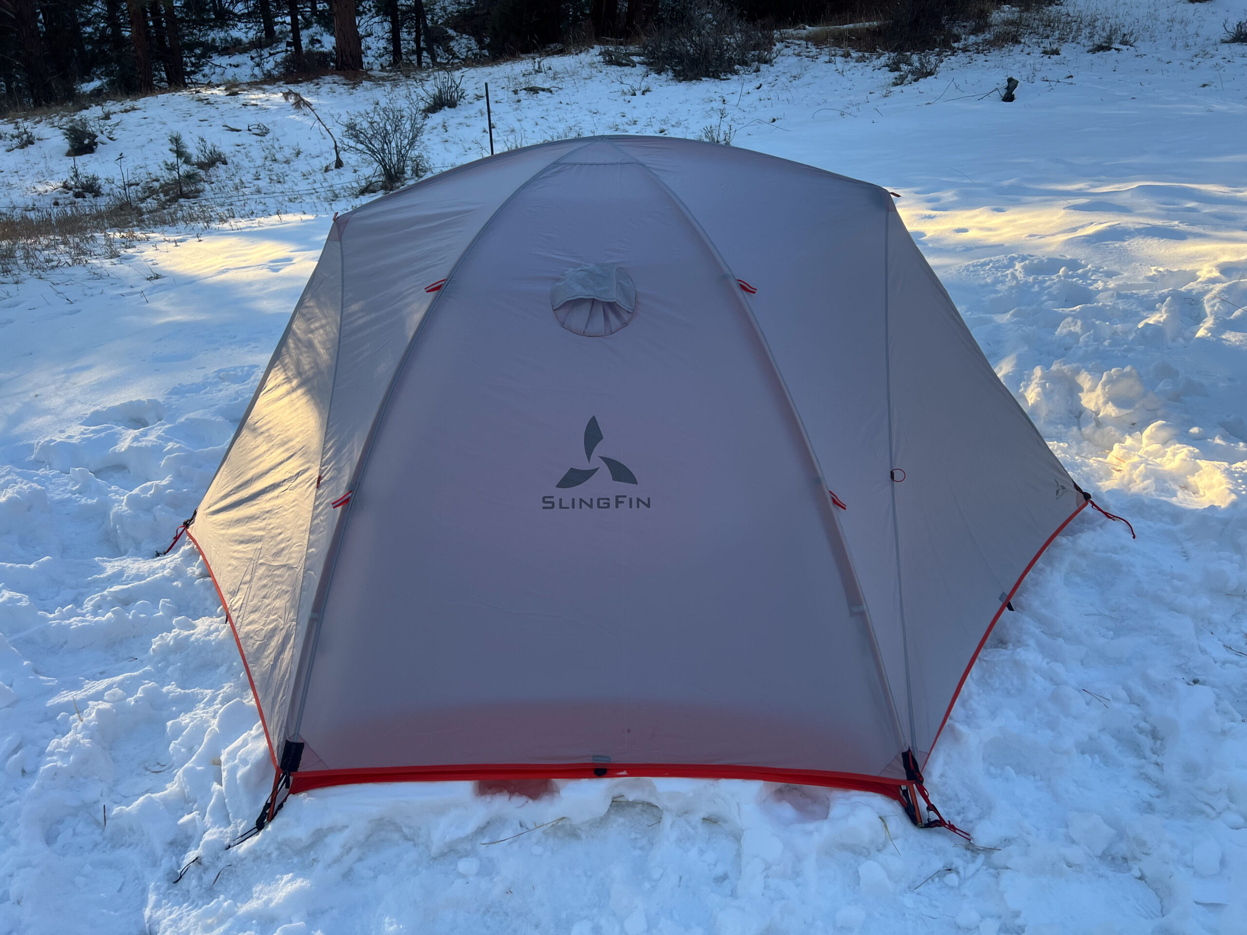 Rear view of the SlingFin CrossBow 2 tent, showcasing its logo and durable material in a snowy setting.