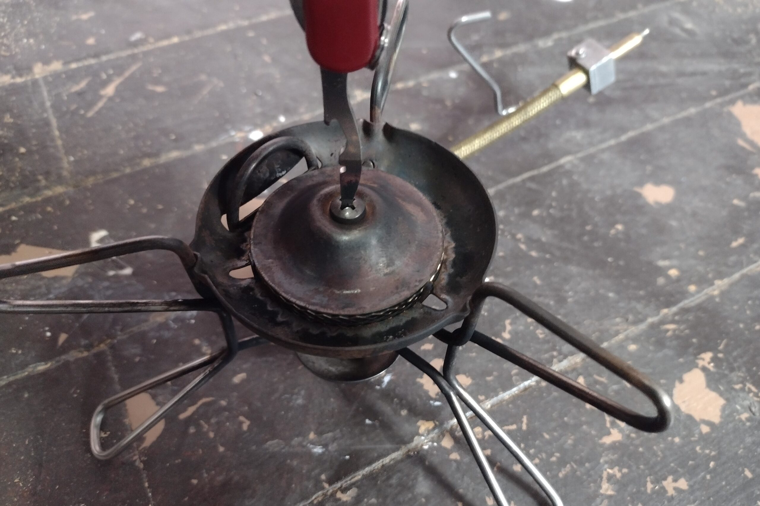 The Victorinox Rambler using its screwdriver to adjust a camp stove burner.