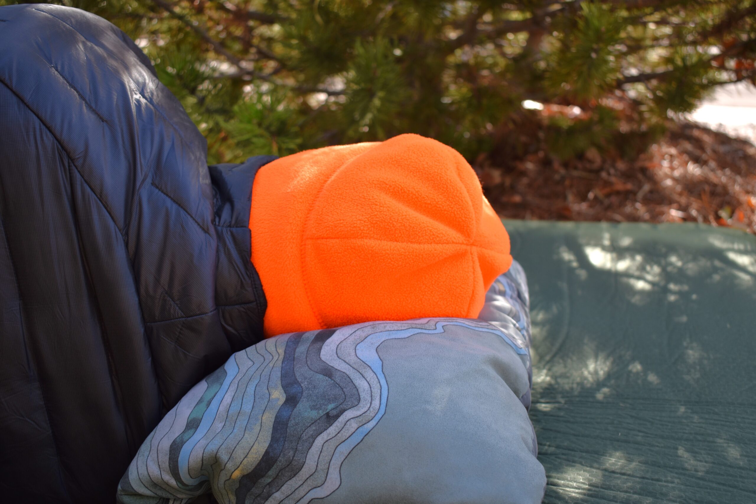 Close up of the Compressible Cinch pillow holding up the author's head while sleeping on his side