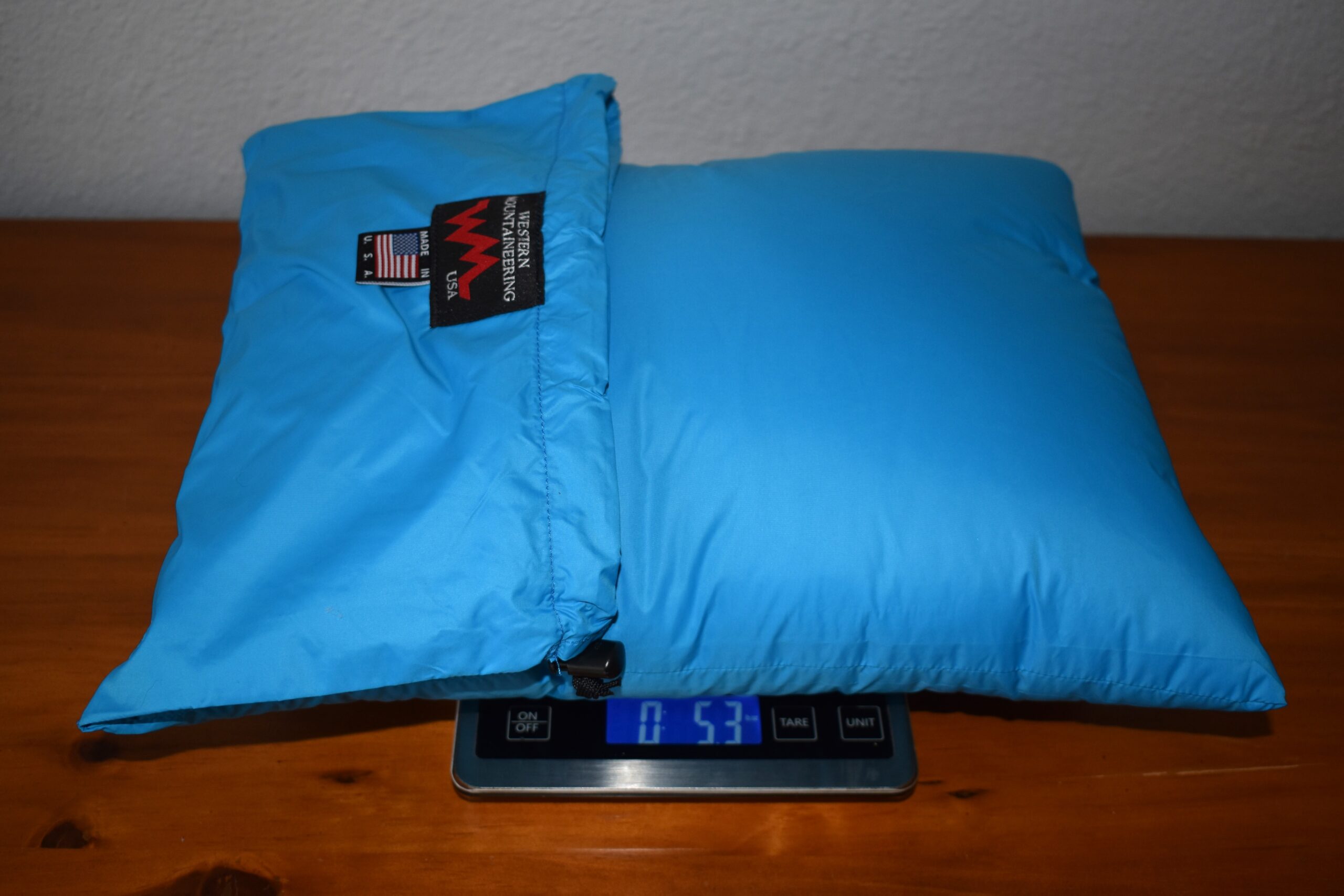 The Cloudrest Down Pillow sits on a kitchen scale that reads 5.3 ounces.