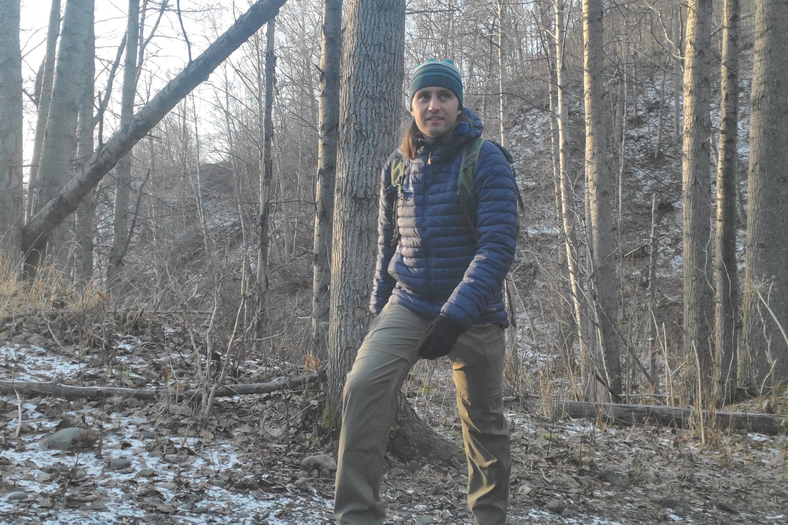 A man hikes in olive green hiking pants.