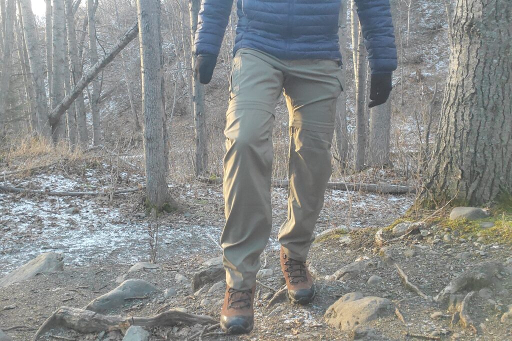 A man hikes along a frosty trail in early winter.