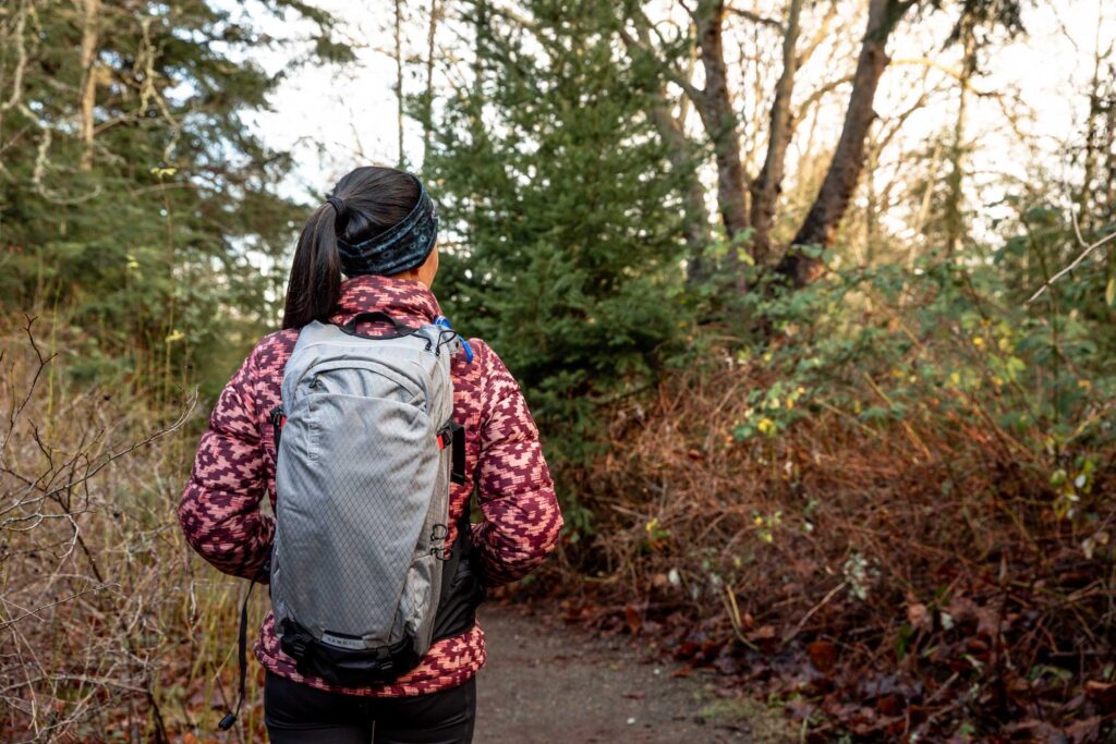 Details of CamelBak H.A.W.G. Pro 20 100oz - showing a person wearing a jacket and the pack in nature