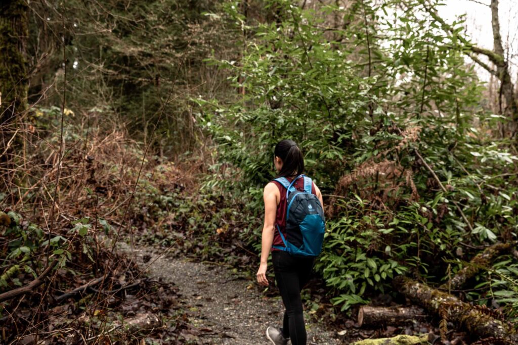 Details of Deuter Speed Lite 13 Hydration Pack - a person walking in the forest with the pack