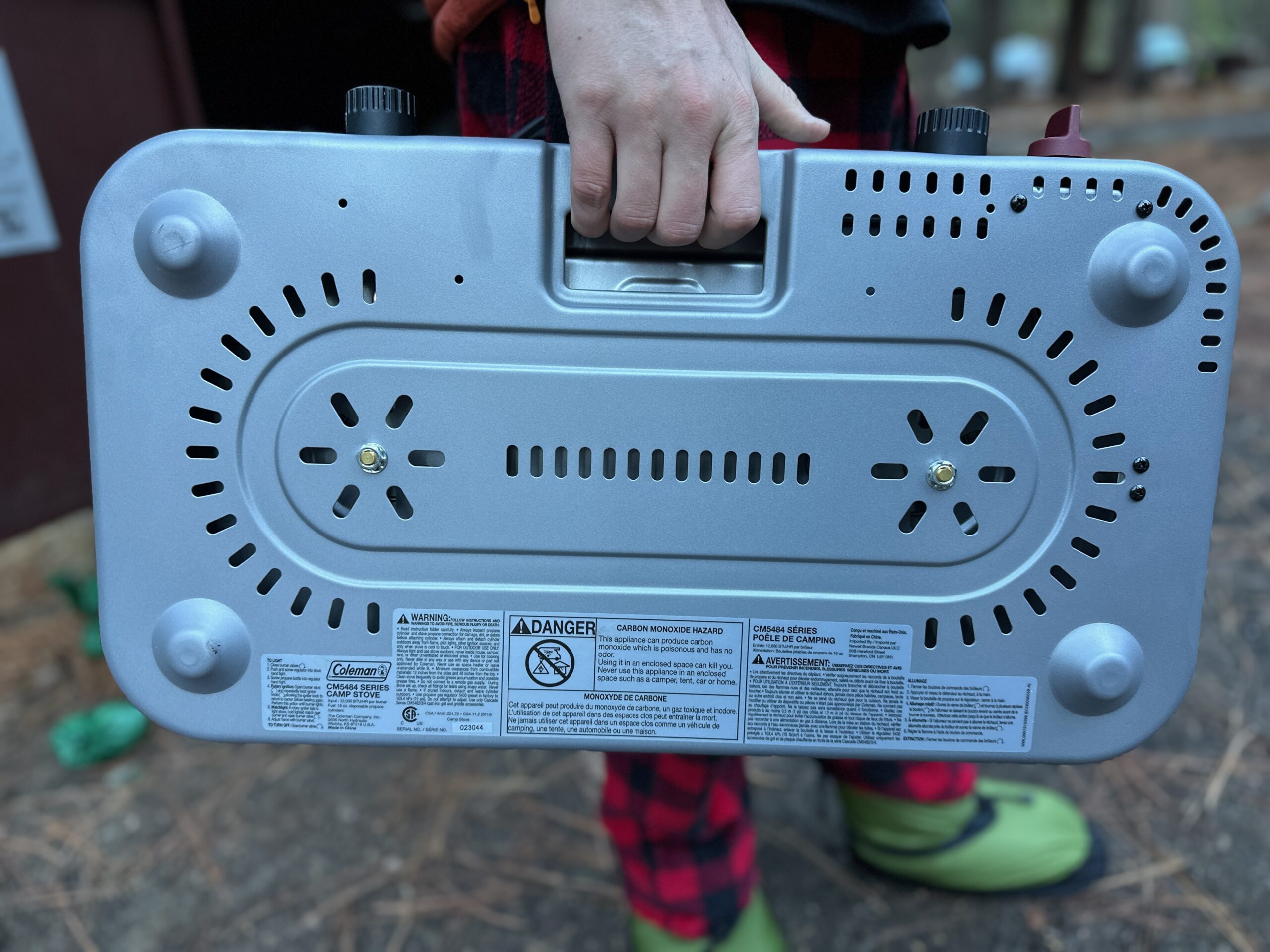 The clever handle of the Coleman stove, hidden on the bottom of the stove. Shown being carried.