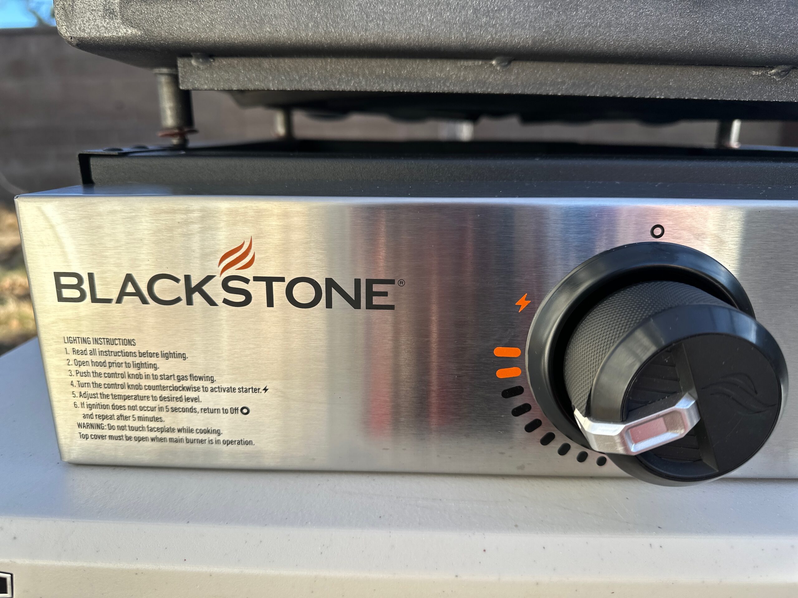 A close up of the self-igniting and temperature control of the Blackstone Original 17" Tabletop Griddle with Hood