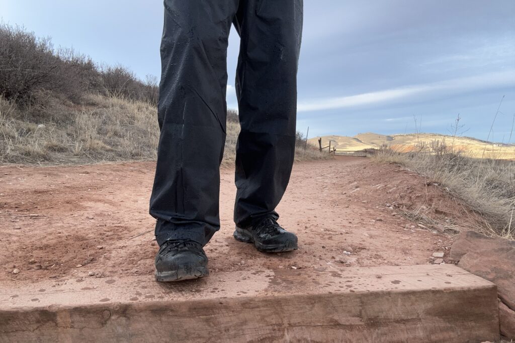 Image of someone wearing the black Columbia Rebel Roamer II on a trail.