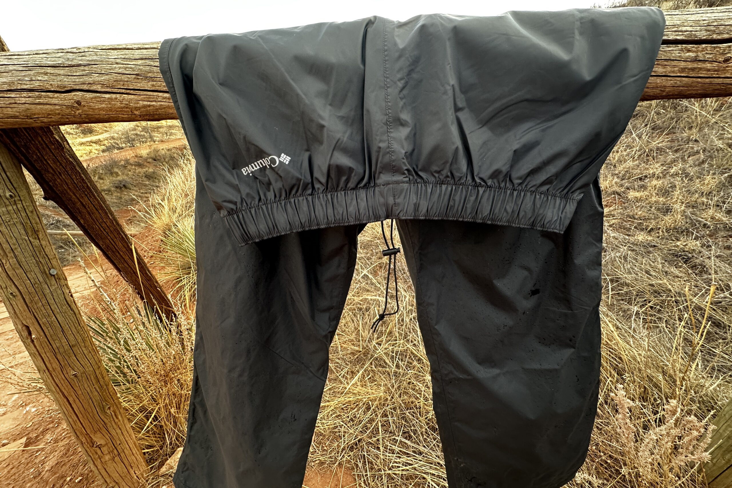 mage of the black Columbia Rebel Roamer II draped on a wood fence rail.