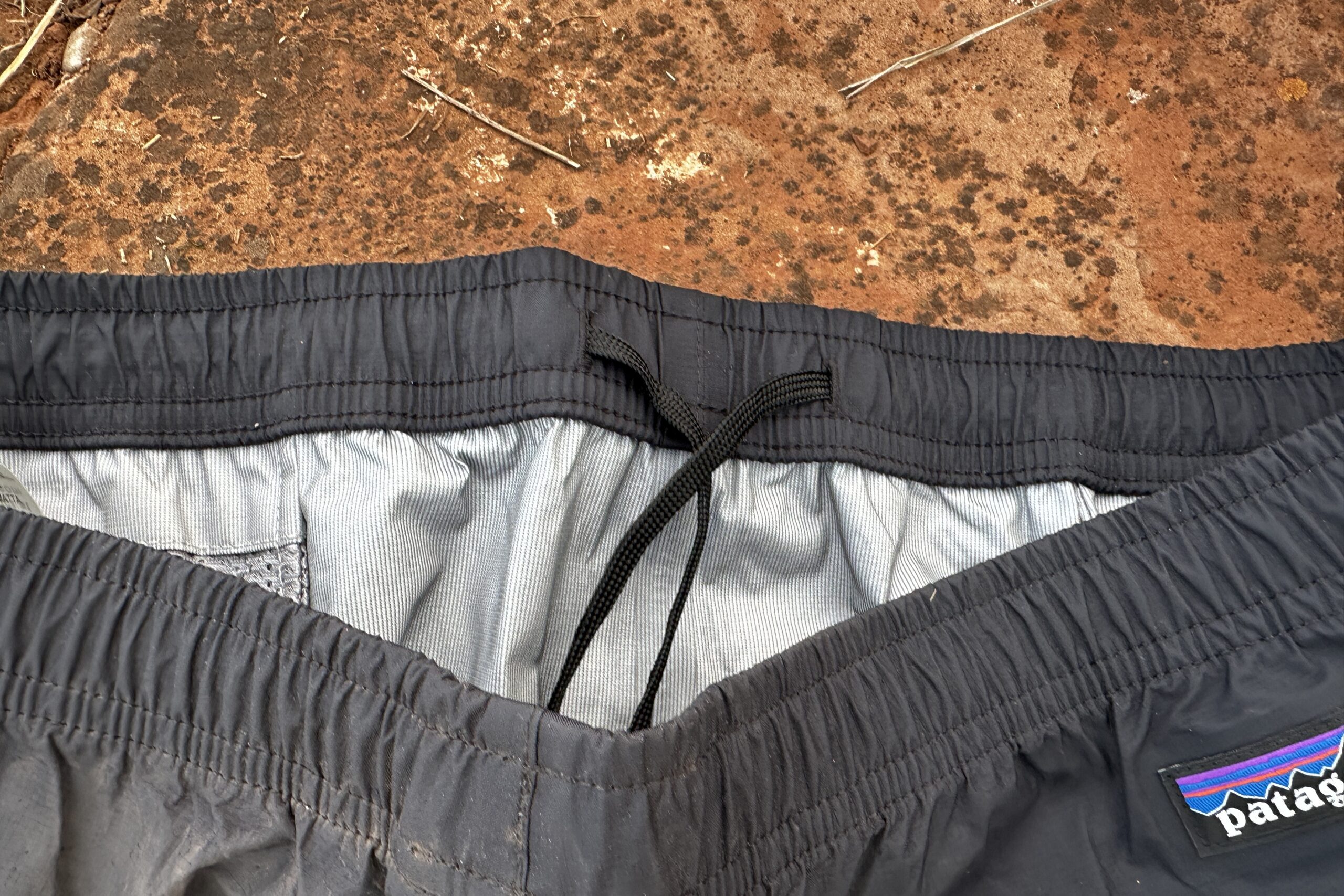 Closeup of the waistband of the black Patagonia Torrentshell rain pants.