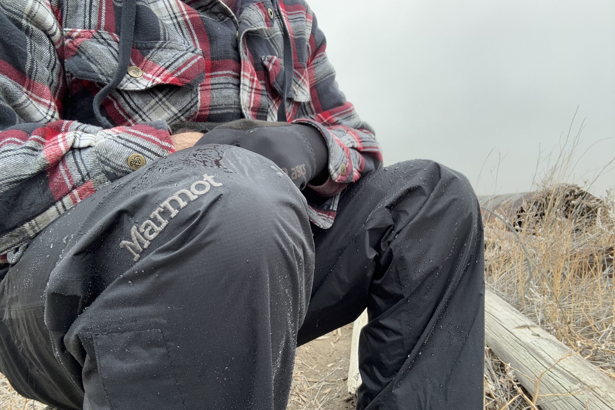 Closeup of someone wearing the black Marmot PreCip Eco rain pants.