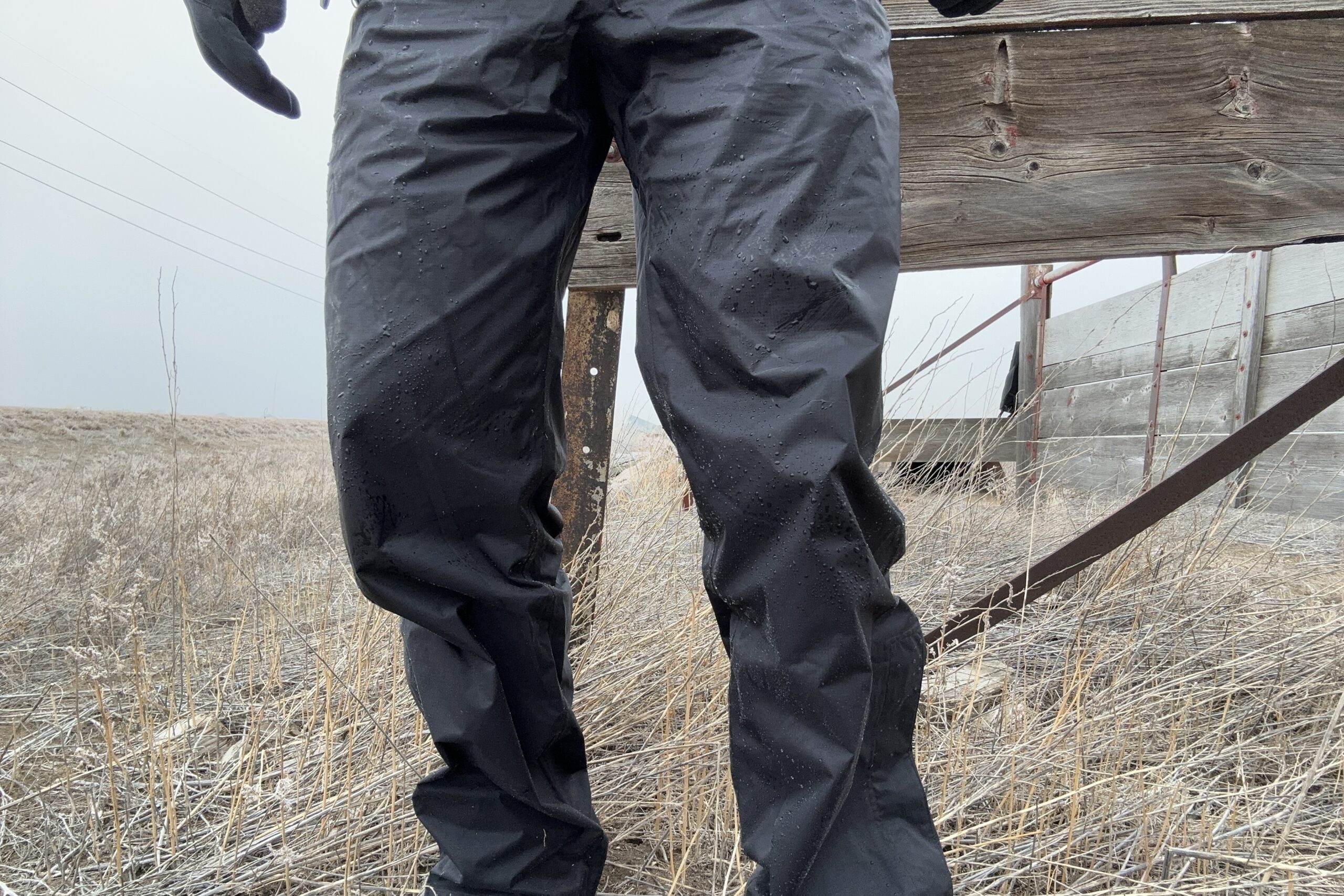 Closeup of someone wearing the black Marmot PreCip Eco rain pants.