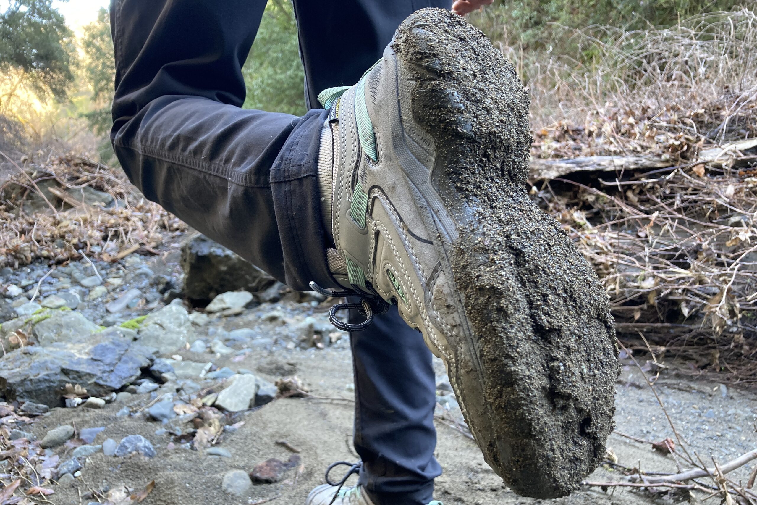 Dirt and mud are caked on the bottom of a Keen hiking shoe.