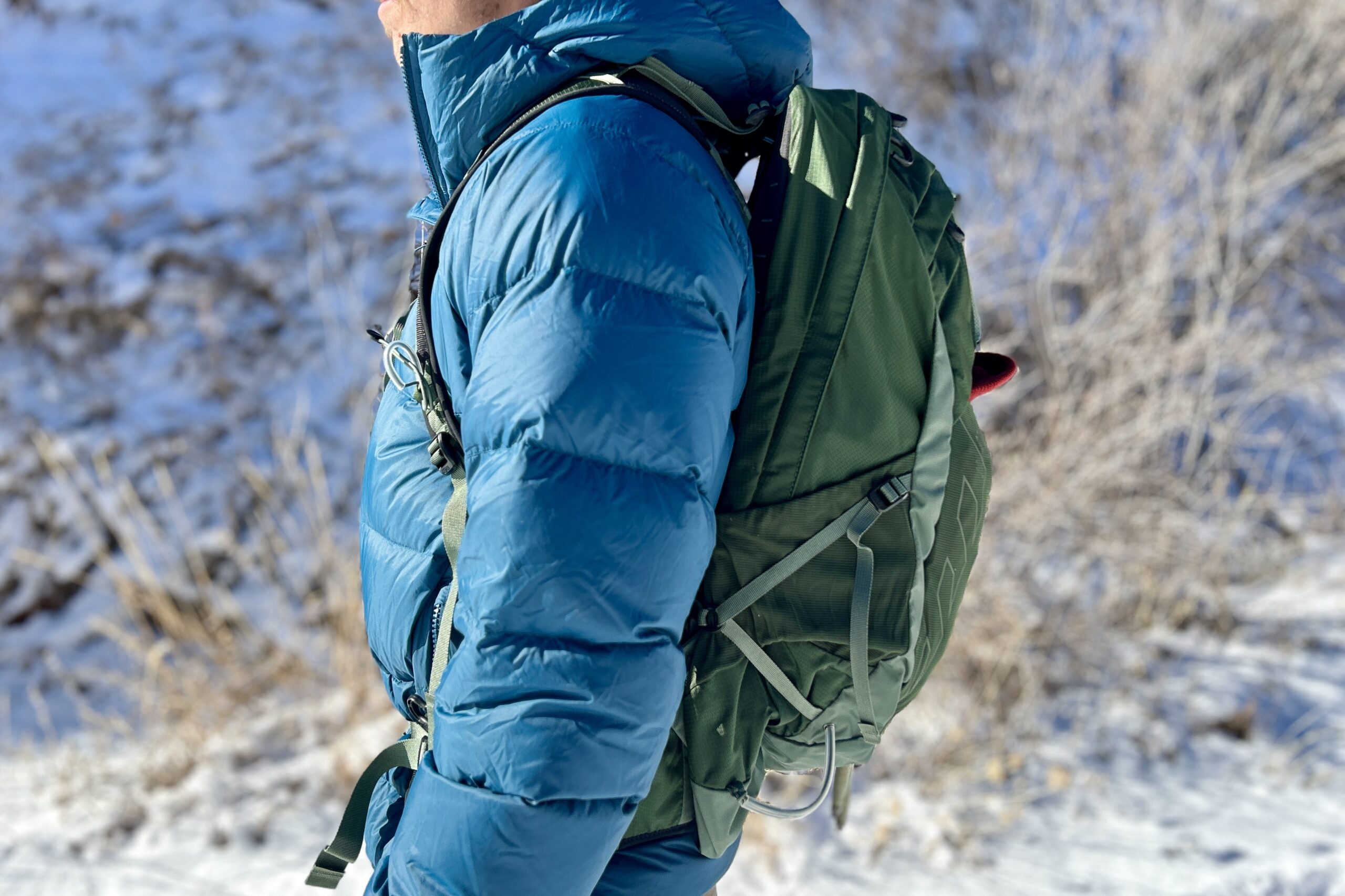 Close up side profile of a person wearing a daypack.